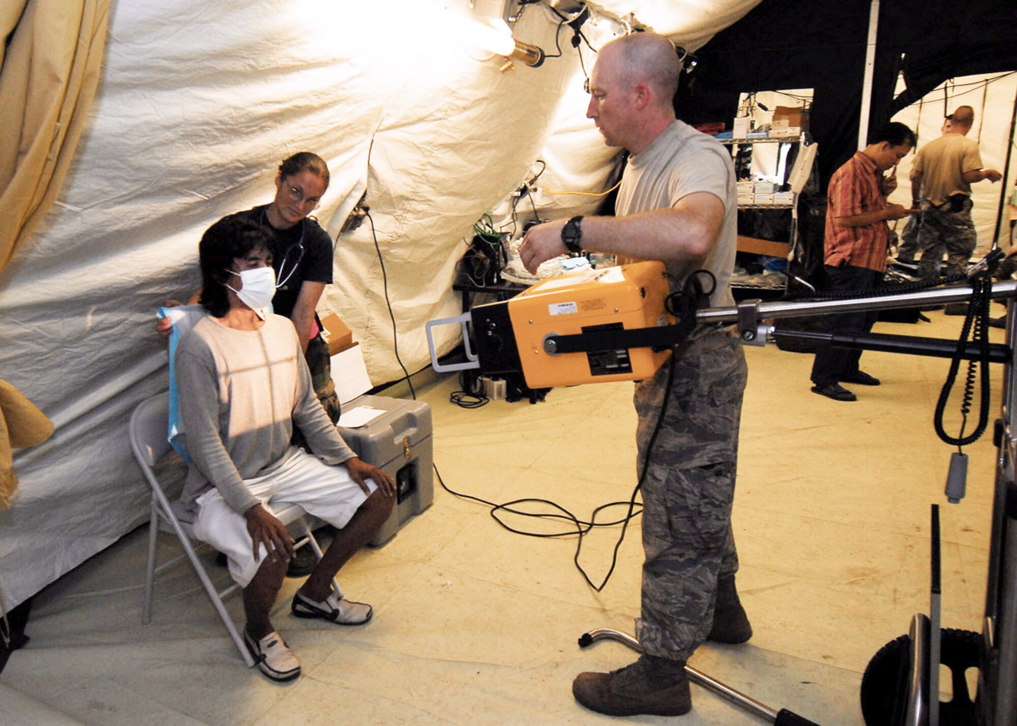 Air Force humanitarian assistance rapid response team members Tech. Sgt. China Mills (left) and Staff Sgt. Clifford Gentry x-ray a man's chest Oct. 7, 2009, in Padang, Indonesia. The HARRT has set up a mobile field hospital to provide medical care to those injured by the recent earthquakes in Indonesia. Sergeant Mills is an individual duty medical technician from the 374th Surgical Operations Squadron at Yokota Air Base, Japan. Sergeant Gentry is a medical technician from the 36th Medical Operations Squadron at Andersen Air Force Base, Guam. (U.S. Air Force photo/Staff Sgt. Veronica Pierce)