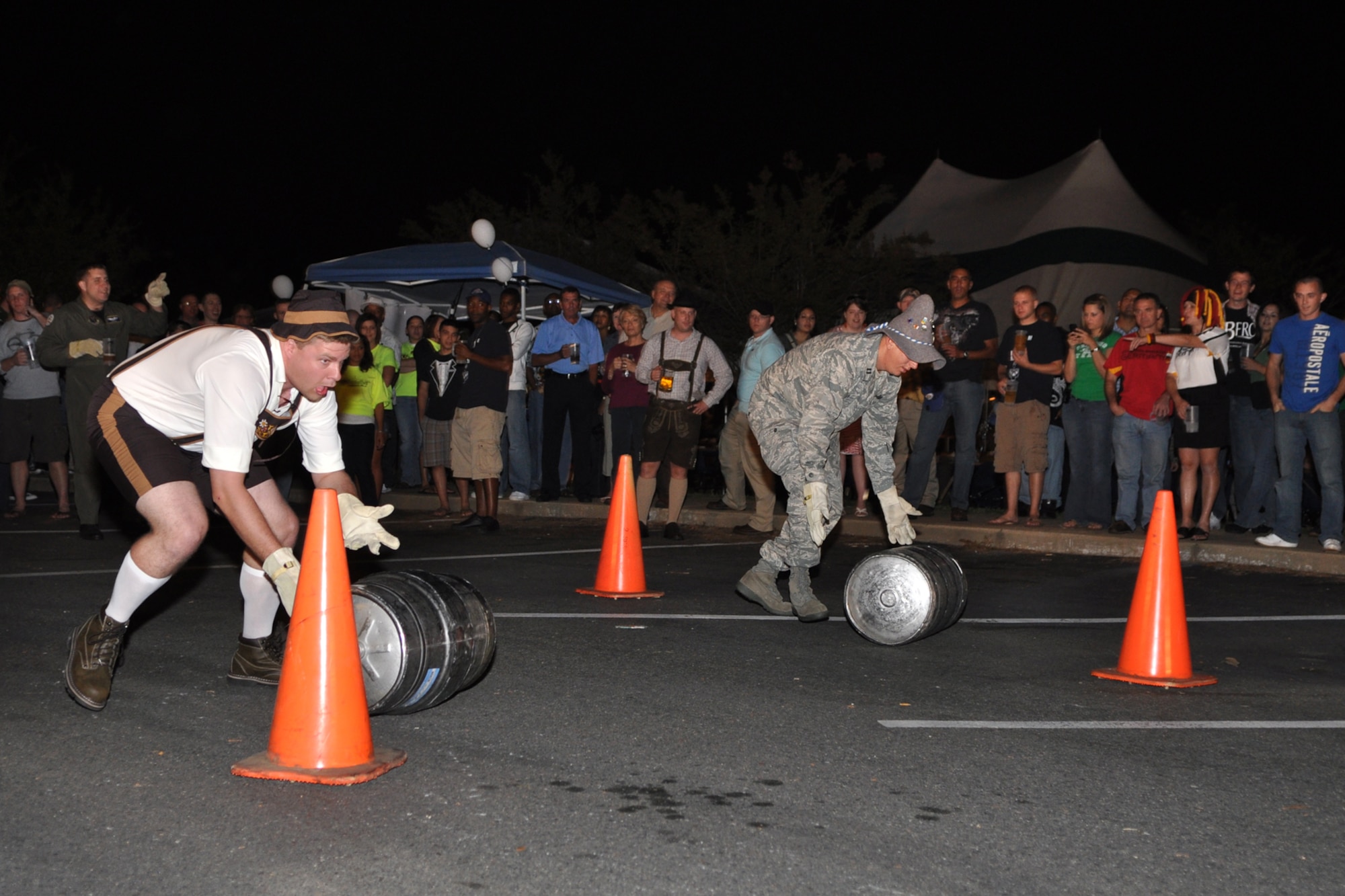Capt. Ryan Cox, 96th Bomb Squadron, electronic warfare officer, competes with Capt. Beau Wingo, Air Force Global Strike Command, missile operator, during the keg-roll contest at the 2nd Annual Oktoberfest celebration at Barksdale Air Force Base, La., October 2, 2009. For the price of admission partygoers enjoyed an authentic German meal, which included bratwurst, schnitzel, German potato salad, and a roll; along with 2 beverages and a commemorative Oktoberfest mug. Side items such as turkey legs and sausage on a stick were also available. Partygoers talked, ate, sang and danced, while some others participated in the keg rolling, costume and yodeling contests. (U.S. Air Force photo/Tech. Sgt. Jeff Walston)