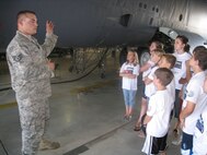 MINOT AIR FORCE BASE, N.D. -- Staff Sgt. Jeremy Fowler, 5th Maintenance Group weapons load team chief, explains to STARBASE students the importance of proper maintenance of the B-52H Stratofortress flown by the 5th Bomb Wing here recently. (Courtesy photo)