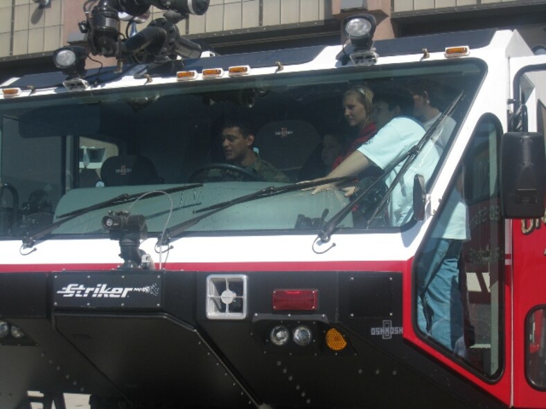 MINOT AIR FORCE BASE, N.D. -- Airman 1st Class Eric Flores, 5th Civil Engineer Squadron firefighter, shows STARBASE students the interior workings of a fire truck here recently. (Courtesy photo)