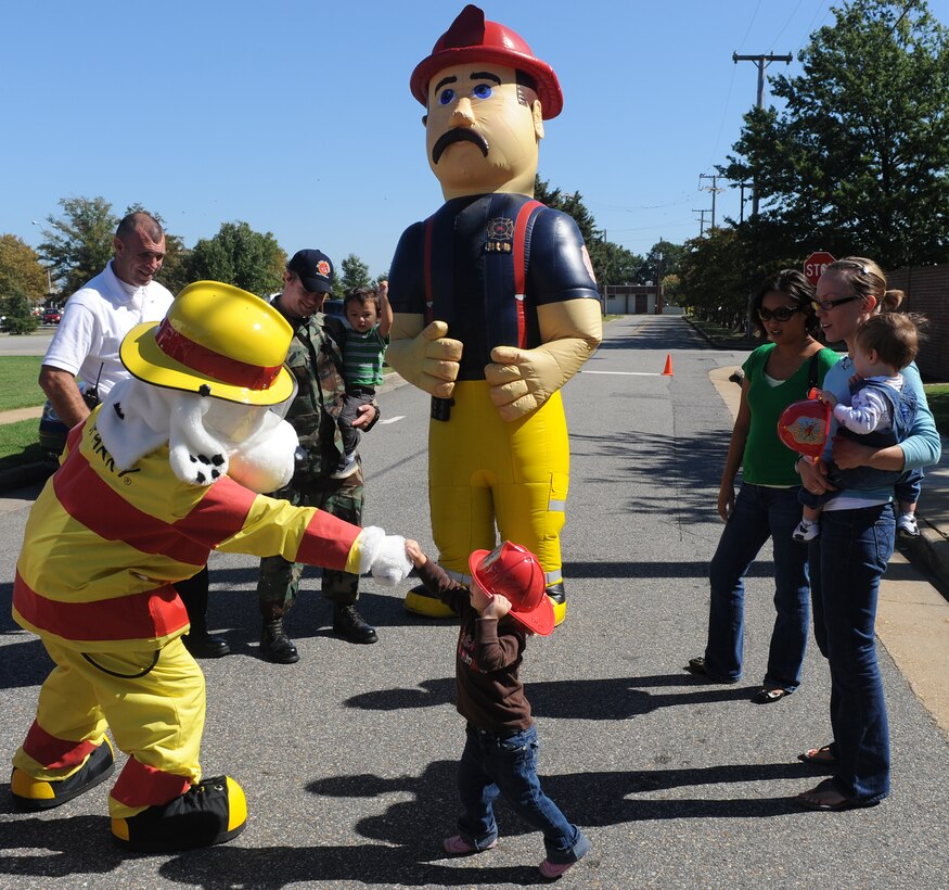 LANGLEY AIR FORCE BASE, Va. -- Abby Guest, daughter of 1st Lt. Jeremy Guest, 1st Civil Engineer Squadron readiness chief, greets Sparky the fire dog here Oct. 7.  Base firefighters are teaching children about fire safety during Fire Prevention Week, Oct. 4-10.   (U.S. Air Force photo/Senior Airman Zachary Wolf)