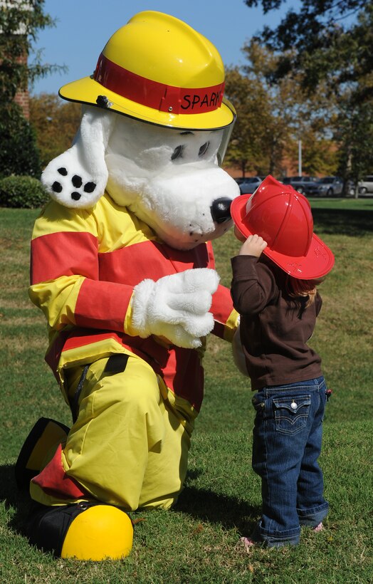LANGLEY AIR FORCE BASE, Va. -- Abby Guest, daughter of 1st Lt. Jeremy Guest, 1st Civil Engineer Squadron readiness chief, learns fire safety tips from Sparky the fire dog here Oct. 7.   Base firefighters are teaching children about fire safety during Fire Prevention Week, Oct. 4-10. (U.S. Air Force photo/Senior Airman Zachary Wolf)