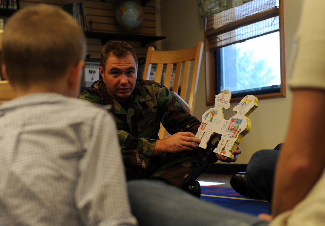 LANGLEY AIR FORCE BASE, Va. -- Staff Sgt. Douglas Reedy, 1st Civil Engineer Squadron firefighter, reads to Bryce Barton, son of Staff Sgt. Billy Barton, 1st Medical Operations Squadron, at the Bateman Library here Oct. 7.  Base firefighters are teaching children fire safety during Fire Prevention Week, Oct. 4-10. (U.S. Air Force photo/Senior Airman Zachary Wolf)