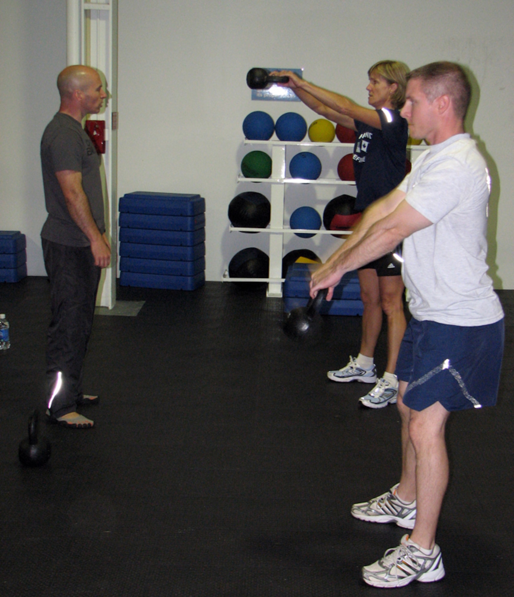 Master Sgt. John Mills, Eastern Air Defense Sector Security Forces member and CrossFit instructor, works with Master Sgt. Patty Crane and Tech. Sgt. Joseph Mondo during a CrossFit class.