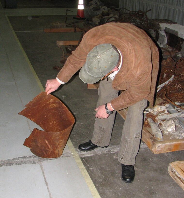 The World Trade Center museum curator holds the steel that will be part of the Eastern Air Defense Sector?s 9-11 Memorial display. 