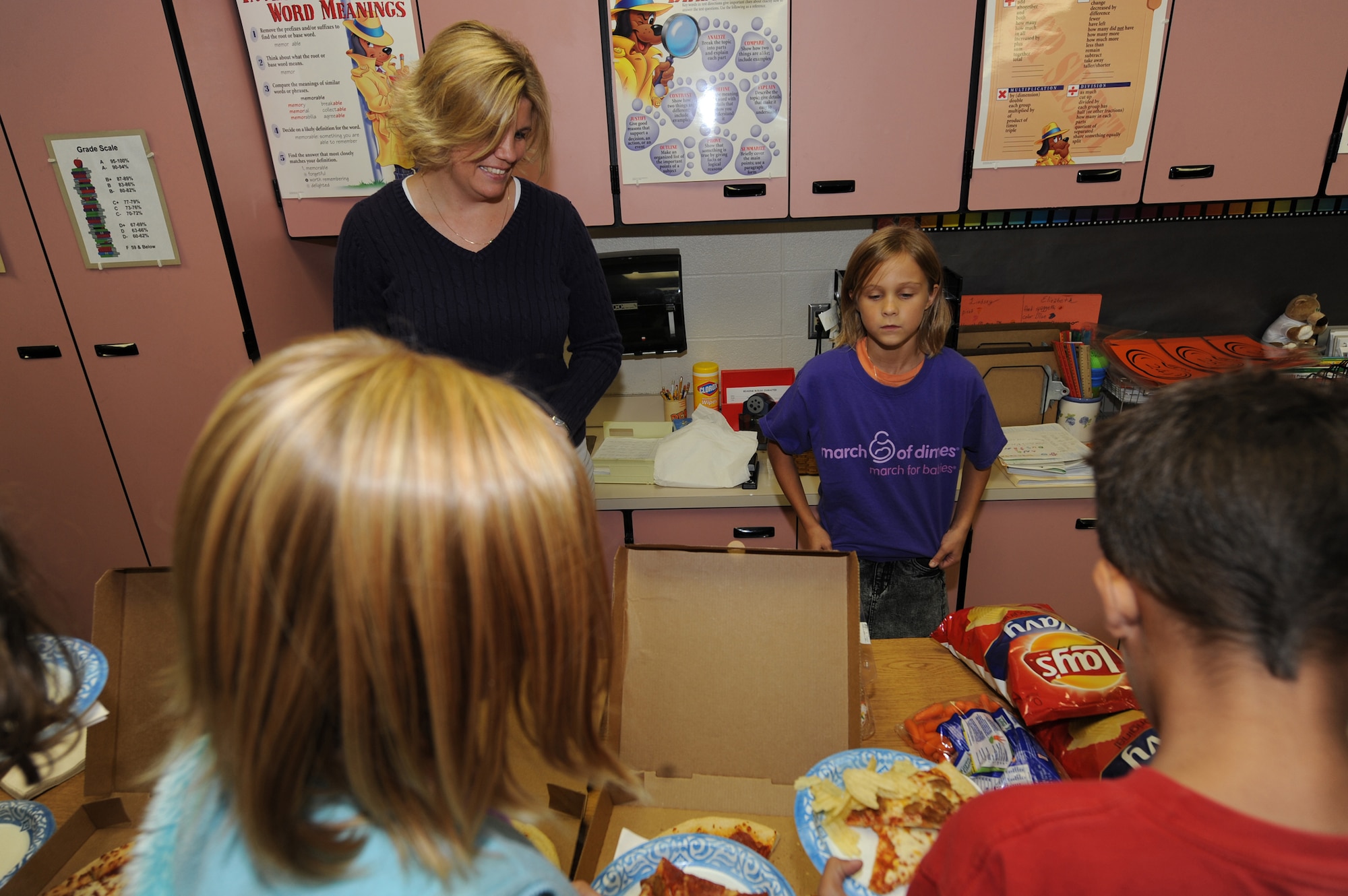 WHITEMAN AIR FORCE BASE, Mo. - Lauren Mahaney, daughter of Senior Airman Richard Mahaney, wearing her March of Dimes t-shirt helps hand out pizza to her 5th grade class, Oct. 6. Laurens class helped raise $178.82 in support of March of Dimes earning them a pizza party for their class. Overall Whiteman Elementary School Raised $947.96 towards March of Dimes. Trey Mahaney, Lauren's little brother, passed away of a heart condition last January and supporting March of Dimes is a way for the Mahaney Family to raise awarenss about the health of babies, preventing birth defects, pre-mature birth and infant mortality. (U.S. Air Force photo by Airman 1st Class Carlin Leslie)