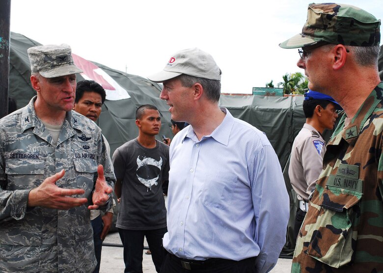 PADANG, Indonesia -- Col. Dan Settergren, 36th Expeditionary Contingency Response Group commander, (left) meets with Ted Osius, Deputy Charge de Affairs of the Disaster Assistance Response Team and Rear Adm. Richard Landolt, Amphibious Force 7th Fleet commander, to explain the Humanitarian Assistance Rapid Response Team mission and capabilities in front of the team's mobile field hospital Oct. 6. (U.S. Air Force photo/Staff Sgt. Veronica Pierce)