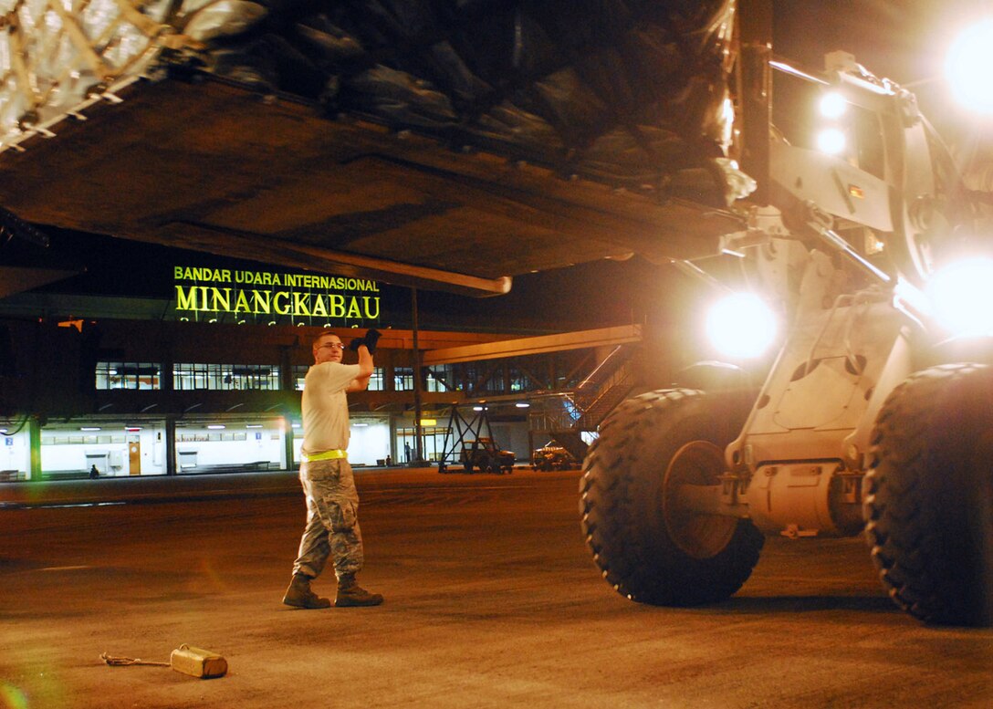 PADANG, Indonesia -- Staff Sgt. Christopher West, 36th Mobility Response Squadron from Andersen Air Force Base, Guam, marshals a forklift carrying medical supplies off of a C-17 Globemaster III Oct. 5. Sergeant West is an air transportation specialist deployed here with the Humanitarian Assistance Rapid Response Team to provide medical assistance for those affected by the recent earthquake. (U.S. Air Force photo/Staff Sgt. Veronica Pierce)