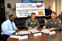 Col. John Wood, center, Col. Steven Chapman, right, and Curtis Fludd sign the Voluntary Protection Program proclamation here Oct. 2 to publicly announce their commitment as leaders to VPP tenets. VPP strives to maintain a safe, healthy workplace and combine clear leadership with focused employee participation in every function of the program. Colonel Wood is the 437th Airlift Wing commander, Colonel Chapman is the 315th Airlift Wing commander and Mr. Fludd is the president of the American Federation of Government Employees, Local 1869. (U.S. Air Force photo/James M. Bowman)