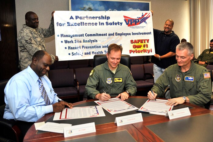 Col. John Wood, center, Col. Steven Chapman, right, and Curtis Fludd sign the Voluntary Protection Program proclamation here Oct. 2 to publicly announce their commitment as leaders to VPP tenets. VPP strives to maintain a safe, healthy workplace and combine clear leadership with focused employee participation in every function of the program. Colonel Wood is the 437th Airlift Wing commander, Colonel Chapman is the 315th Airlift Wing commander and Mr. Fludd is the president of the American Federation of Government Employees, Local 1869. (U.S. Air Force photo/James M. Bowman)