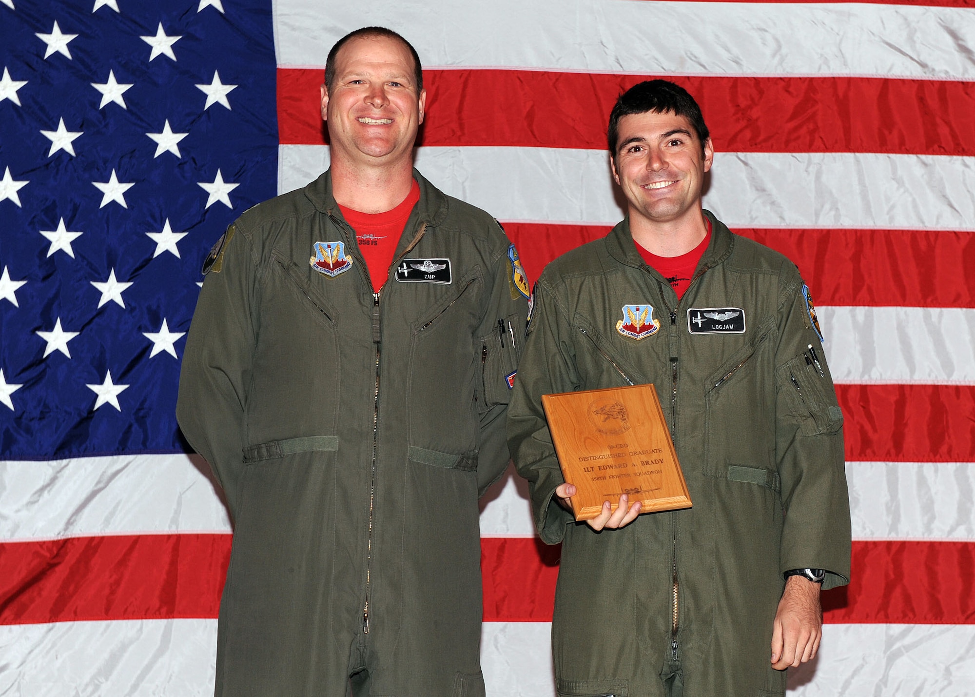 Lt. Col. Thomas Zupancich, 358th Fighter Squadron commander, presents 1st Lt. Edward Brady, 358th Fighter Squadron, with the distinguished graduate award during the A-10A course graduation here Oct. 2. Lieutenant Brady was one of nine pilots to graduate the last A-10A class. After 32 years of qualifying pilots for the A-10A, students will now learn how to fly the A-10C, which has upgraded avionics and weapons delivery capabilities. The course is a six-month class that provides the pilots with 215 hours of academics, 52 hours in the simulator, 41 sorties, and 87 hours of flying time. Lieutenant Brady was also the class "Top Gun." Five of Lieutenant Brady’s classmates will be assigned to the 25th Fighter Squadron, Osan Air Base, Republic of Korea, which is the last unit still flying the A-10A. All of the pilots will eventually return to Davis-Monthan for the conversion training course. (U.S. Air Force Photo/Senior Airman Jacqueline Romero)