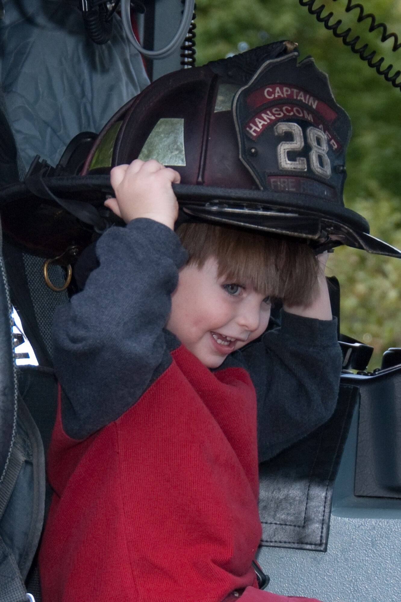 HANSCOM AIR FORCE BASE, Mass. – Garrett McNulty from Room 1 at the Child Development Center, tries on a fire helmet during a visit to Center by members of the Hanscom Fire Department for Fire Prevention Week. The Fire Department hosted a number of educational events across the base throughout the week to educate the base community on the importance of fire safety. On Oct. 10, the Fire Department will hold a Fire Prevention Walk at Castle Park from 11 a.m. to 4 p.m. The event will include several fire safety demonstrations, an amusement area for children and plenty of food and refreshments in addition to fire prevention giveaways and prizes. The entire Hanscom community is welcome to attend the free family event which is part of Hanscom’s Year of the Air Force Family celebrations. (U.S. Air Force photo by Rick Berry)