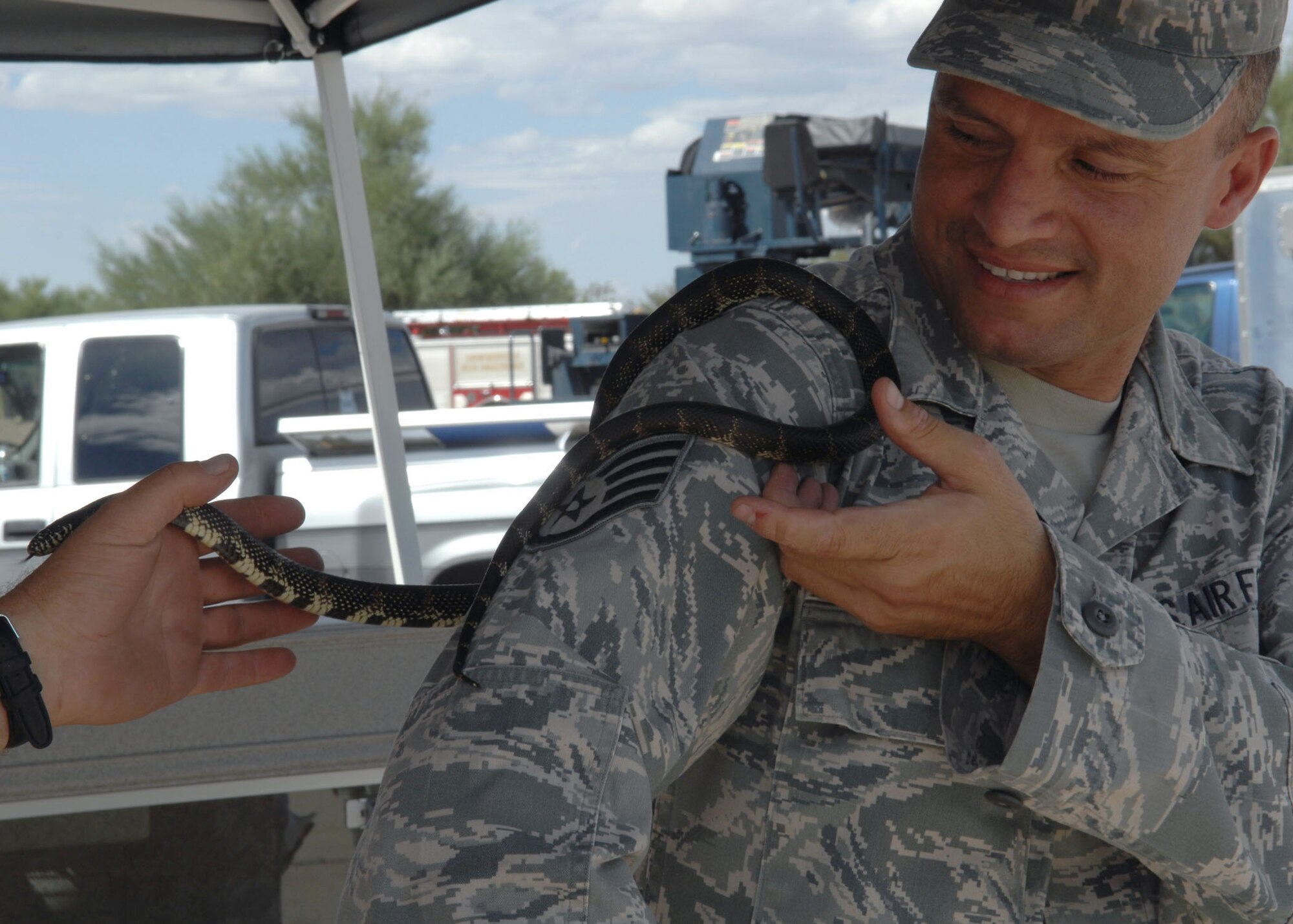 Staff Sgt. Pietro Giacalone, 355th Civil Engineer Squadron, learns more about a Kingsnake during  Safety Day at Heritage Park Sept. 30. The snake, as well as other Tucson-native creatures, was part of a display teaching Airmen about the safe handling of dangerous local species.  (U.S. Air Force photo/ Airman Jerilyn Quintanilla)