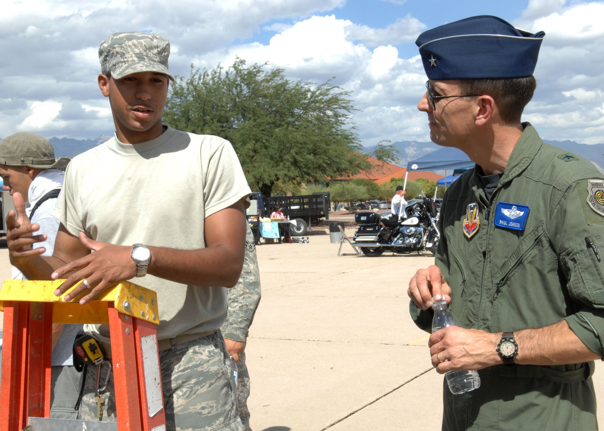 Brig. Gen. Paul Johnson, 355th Fighter Wing commander, listens as Senior Airman Michael Jones, 355th Civil Engineer Squadron, explains the dangers and precautions Airmen should take when dealing with ladders. The general and hundreds of Airmen attended Safety Day at Heritage Park Sept. 30. The event was sponsored by the 355th Fighter Wing Safety office and featured safety booths, displays and demonstrations from different squadrons on base. (U.S. Air Force photo/Airman Jerilyn Quintanilla)