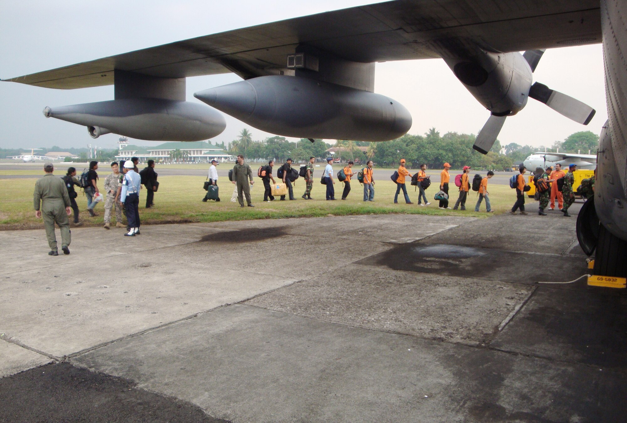 Members of the 353rd Special Operations Group, Indonesian air force members and emergency response teams board a MC-130P Combat Shadow Oct. 2, 2009, at Bandung, Indonesia. The group immediately started moving emergency response teams, equipment and relief supplies to the Padang area to support humanitarian relief operations after a 7.6 magnitude earthquake and a slightly smaller one struck the area Sept. 29 and Oct. 1. The 353rd SOG Airmen are from Kadena Air Base, Japan. (Courtesy photo) 