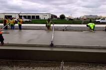 MINOT AIR FORCE BASE, N.D. -- Construction workers lay down heavy duty concrete for the transient parking apron that is 16 inches thick here, Oct. 6. Construction work like this is one of the many improvements planned for Minot AFB. (U.S. Air Force photo by Senior Airman Michael Veloz)