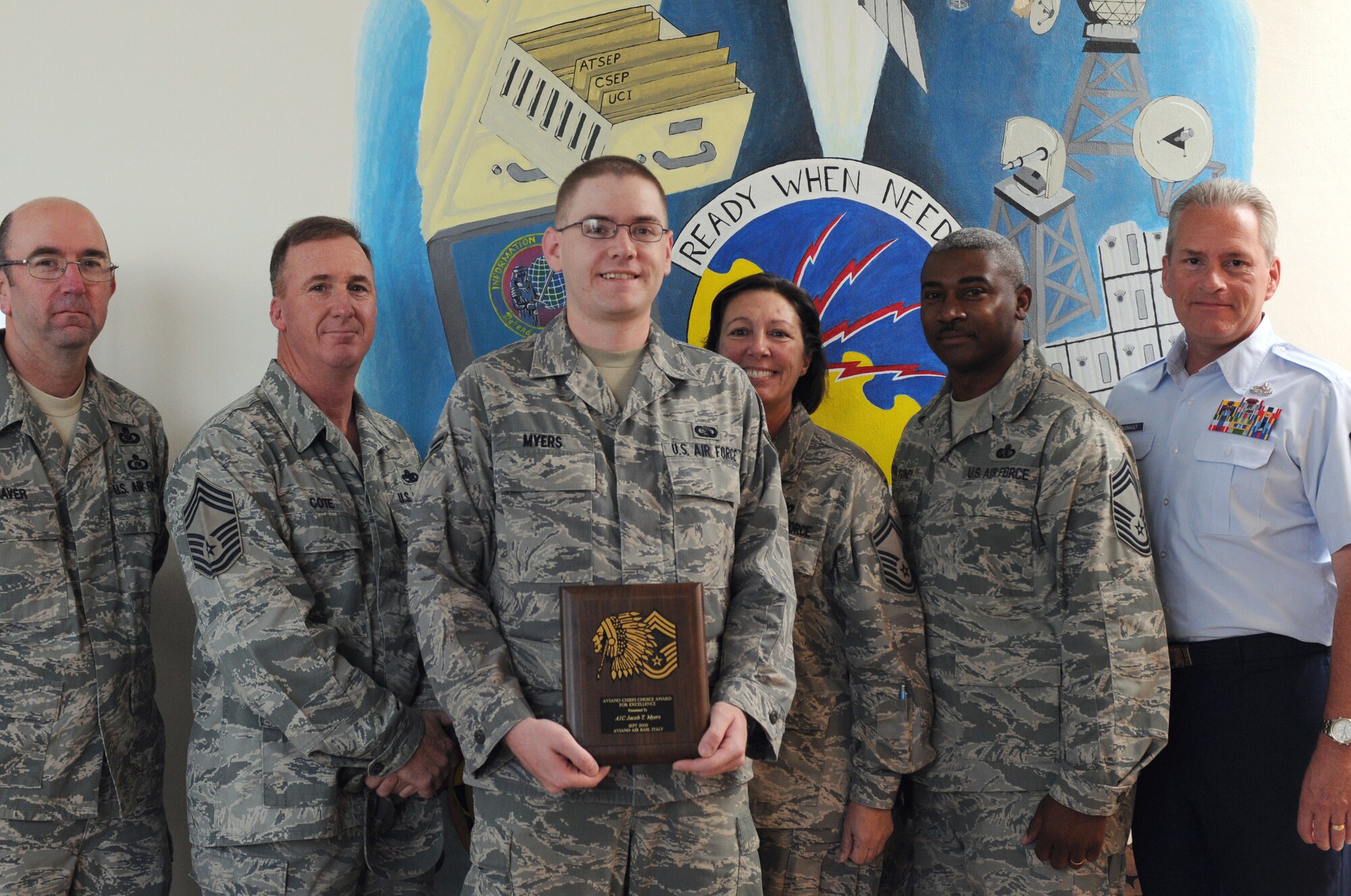 Airman 1st Class Jacob Myers, 31st Communications Squadron, recieves the Aviano Chief's Choice Award for September 2009 from (Chief Select) Senior Master Sgt. Linda Jacobs, 31st Civil Engineer Squadron chief enlisted manager, along with fellow Aviano chiefs. (U.S. Air Force photo/ Senior Airman Nadine Barclay)