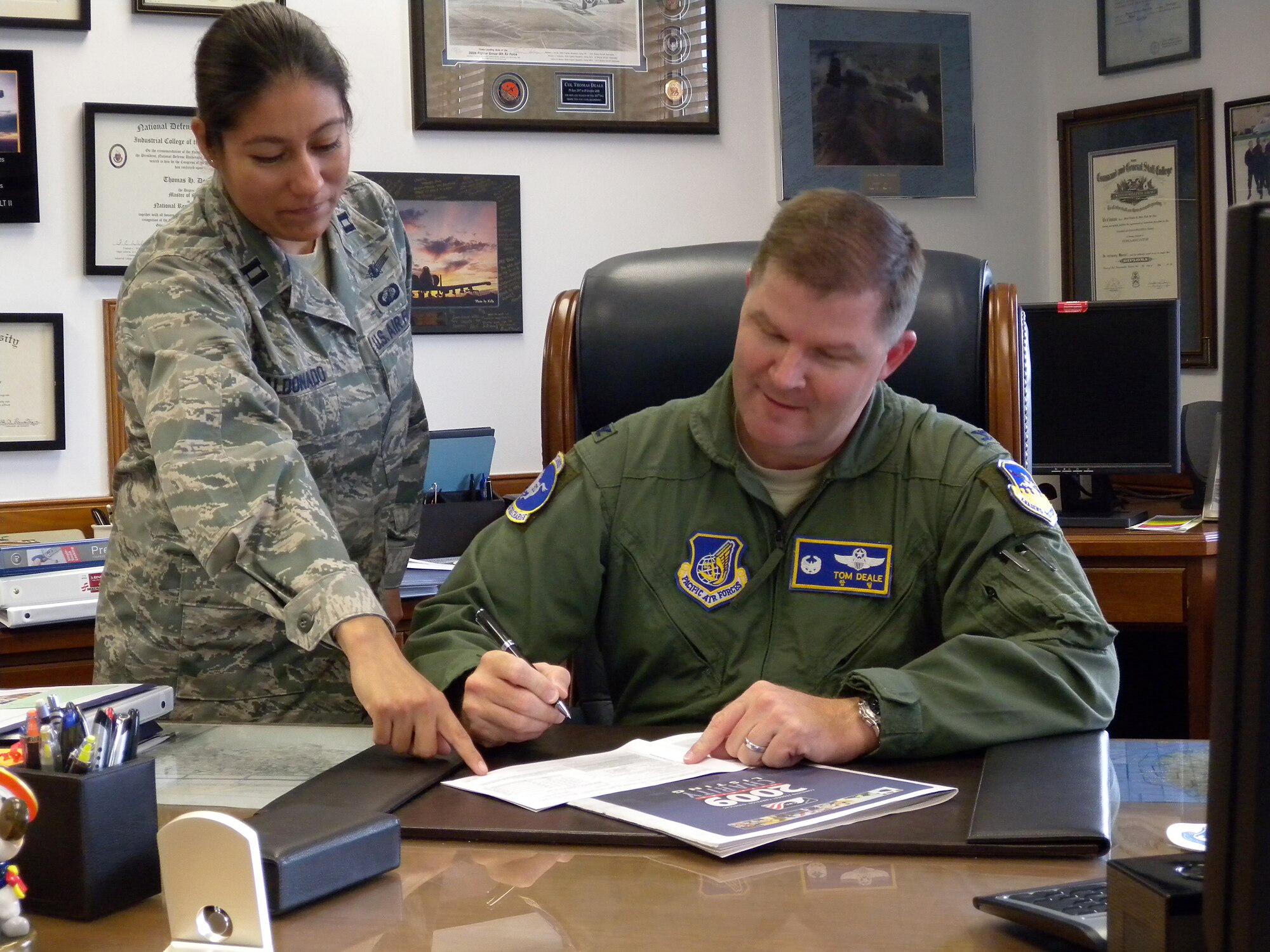 Capt. Martha Maldonado, left, shows Col. Thomas Deale where to sign on his 2009 Combined Federal Campaign form Oct 7 at Osan Air Base, Republic of Korea.  The CFC began here Oct. 5 and runs through Nov. 4. The mission of the CFC is to promote and support philanthropy through a program that is employee focused, cost-efficient, and effective in providing all federal employees the opportunity to improve the quality of life for all. Captain Maldonado is the 51st Fighter Wing CFC Project Officer and Colonel Deale is the 51st Fighter Wing commander. (U.S. Air Force photo/Tech. Sgt. Sheri Kangas)