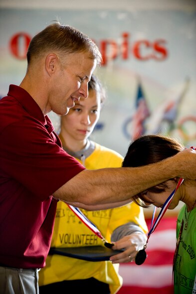 MISAWA AIR BASE, Japan -- Col. R.C. Craig, 35th Fighter Wing vice commander, hangs a medal around the neck of a Misawa Air Base Special Olympics athlete during the closing ceremonies of the 23rd annual Special Olympics in Hanger 949 Oct. 3. Every athlete who participated received a medal. (U.S. Air Force photo/Staff Sgt. Samuel Morse)