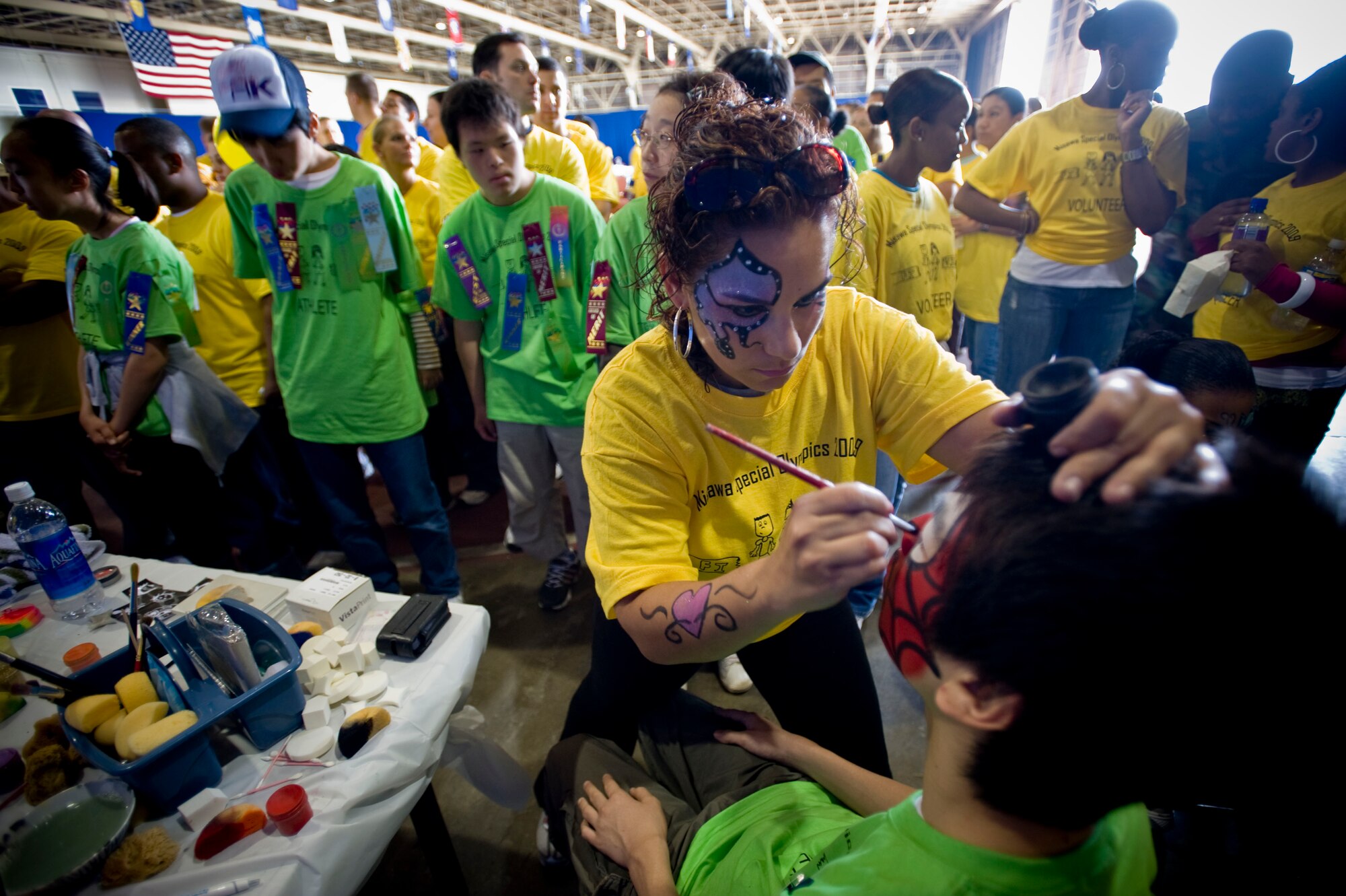 MISAWA AIR BASE, Japan -- Omaira Garcia paints a design on an athlete's face in Hangar 949 Oct. 3. Ms. Garcia gave many of the athletes the opportunity to impersonate their favorite superheroes. (U.S. Air Force photo/Staff Sgt. Samuel Morse)