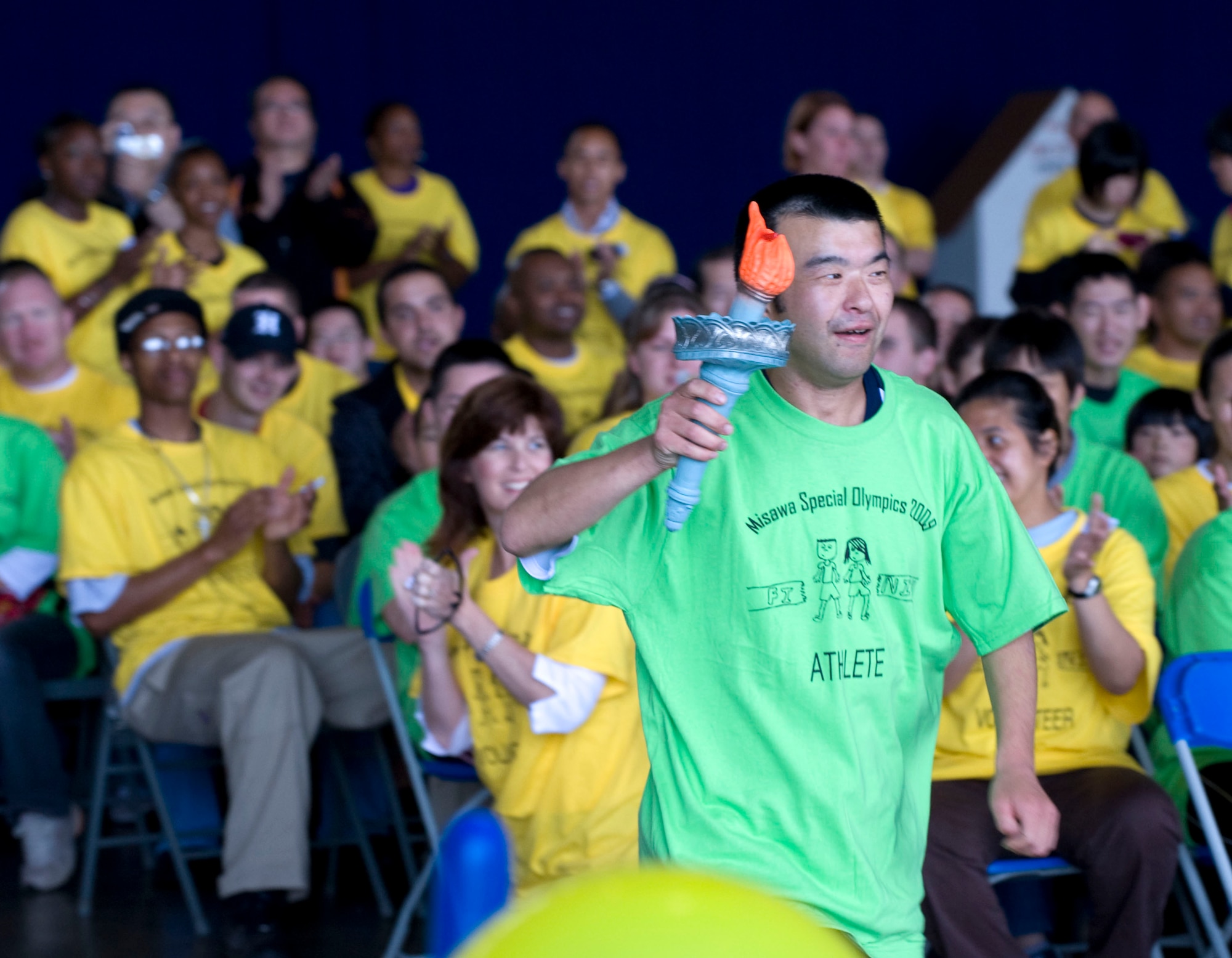 MISAWA AIR BASE, Japan -- An athlete runs with a torch during the Special Olympics opening ceremony, which was held in Hangar 949 Oct. 3. Misawa Air Base hosted the 23rd annual Special Olympics, strengthening ties with the local community. (U.S. Air Force photo/ Staff Sgt. Samuel Morse)