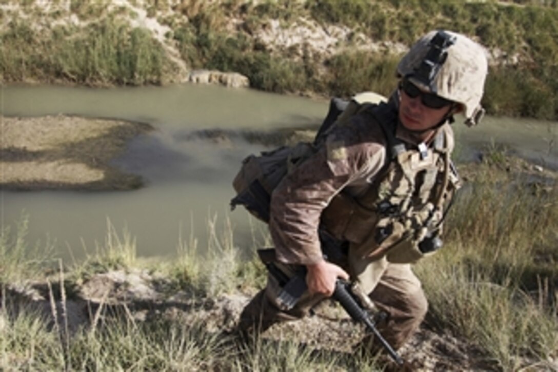 U.S. Navy Petty Officer 2nd Class Shawn McKinney, attached to Alpha Company, 1st Battalion, 5th Marine Regiment, climbs the bank after crossing a river during a patrol in the Nawa district of Helmand province, Afghanistan, on Sept. 30, 2009.  The battalion is a combat element of Regimental Combat Team 3, which conducts counterinsurgency operations in partnership with Afghan National Security Forces in southern Afghanistan.  