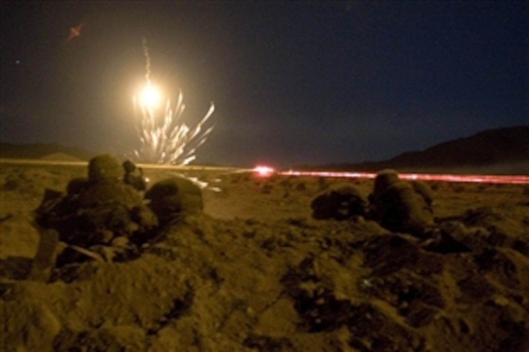 Machine guns fire red tracer rounds at enemy vehicles with an illumination flare overhead, Sept. 27, 2009 at U.S Marine Corps Air Ground Combat Center Twentynine Palms, Calif. The 1st Battalion, 3rd Marine Regiment, concluded the second phase of the Clear, Hold, Build Exercise after five days of combined arms urban operations. 