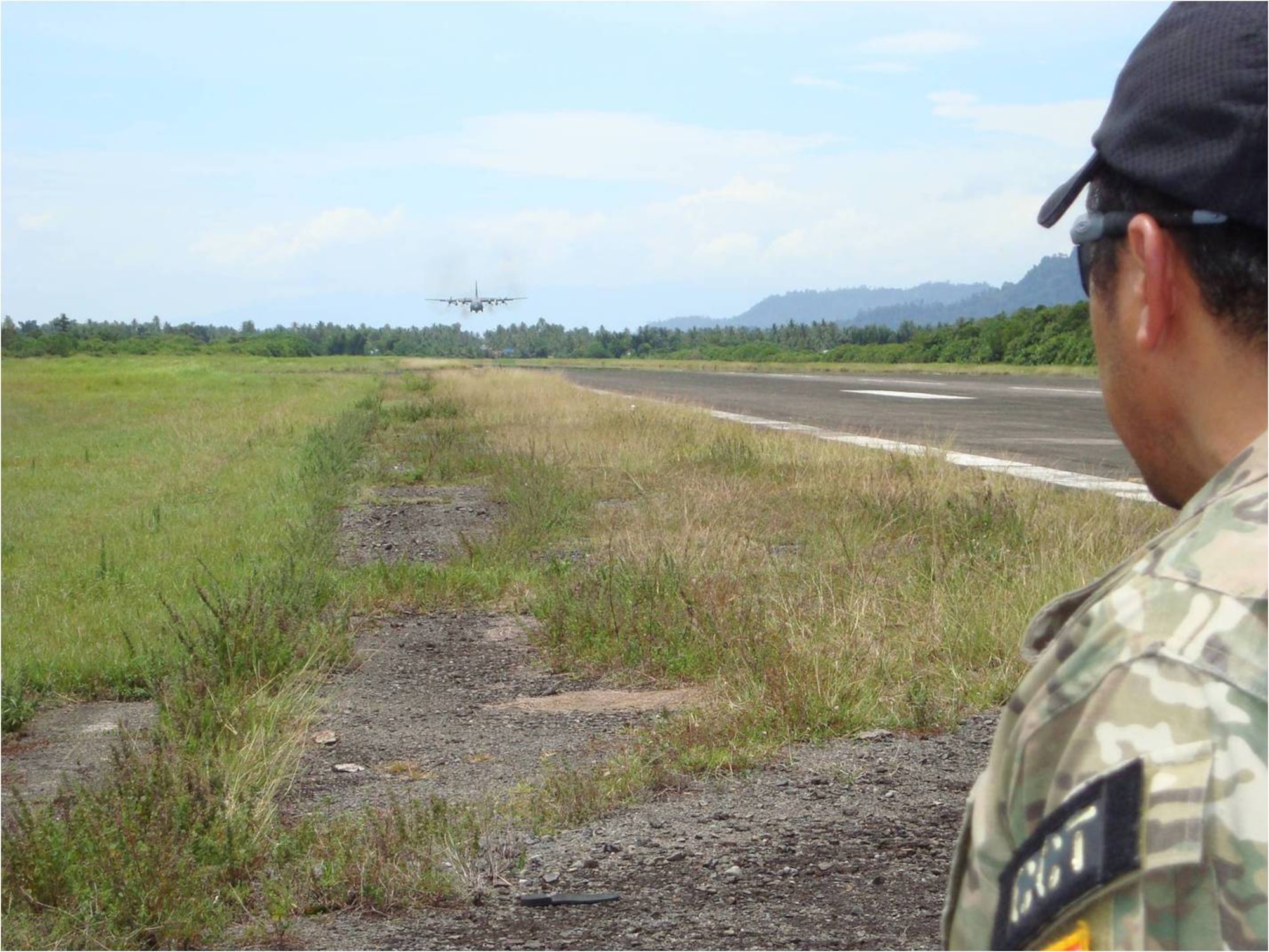 TABING AIRFIELD, Indonesia -- A combat controller from the 353rd Special Operations Group, guides an MC-130P Combat Shadow as it lands here Oct. 4. U.S. and Indonesian military officials surveyed and opened the closed airfield to support humanitarian relief operations near Padang in western Indonesia. MC-130P aircrews have flown more than 15 flights, moved about 100 people, and more than 160,000 pounds of cargo throughout the affected area.  (Courtesy photo)