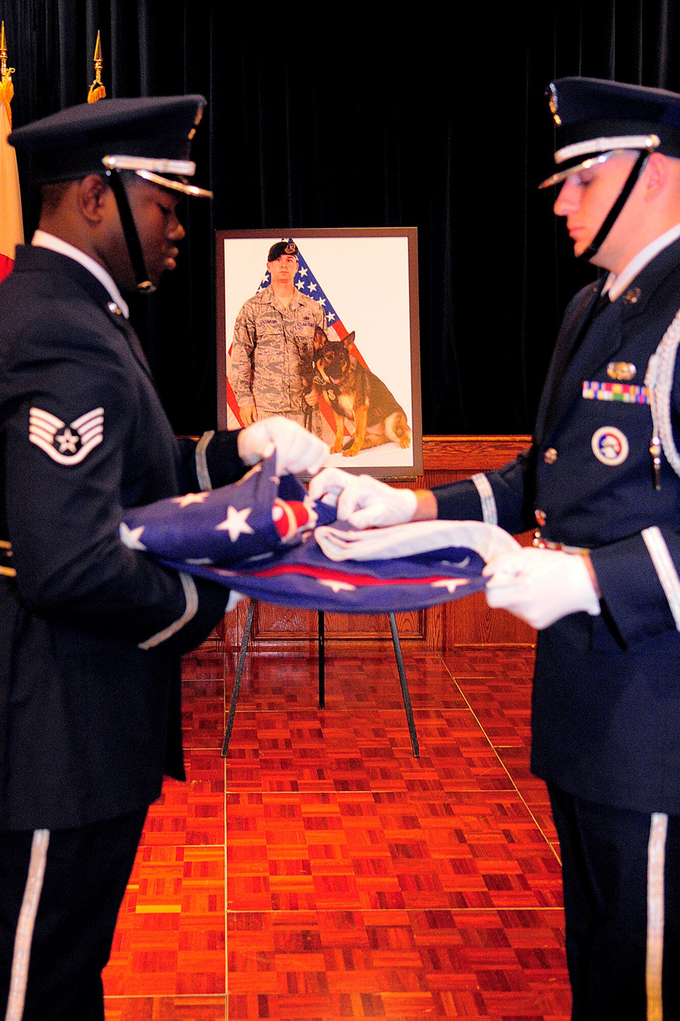 YOKOTA AIR BASE, Japan -- Members of the Yokota Air Base Honor Guard fold a flag during a recent memorial service at the enlisted club here for Pixi, a 3-year-old German Shepherd military working dog assigned to the 374th Security Forces Squadron. (U.S. Air Force photo/Airman 1st Class Michael Dillon)