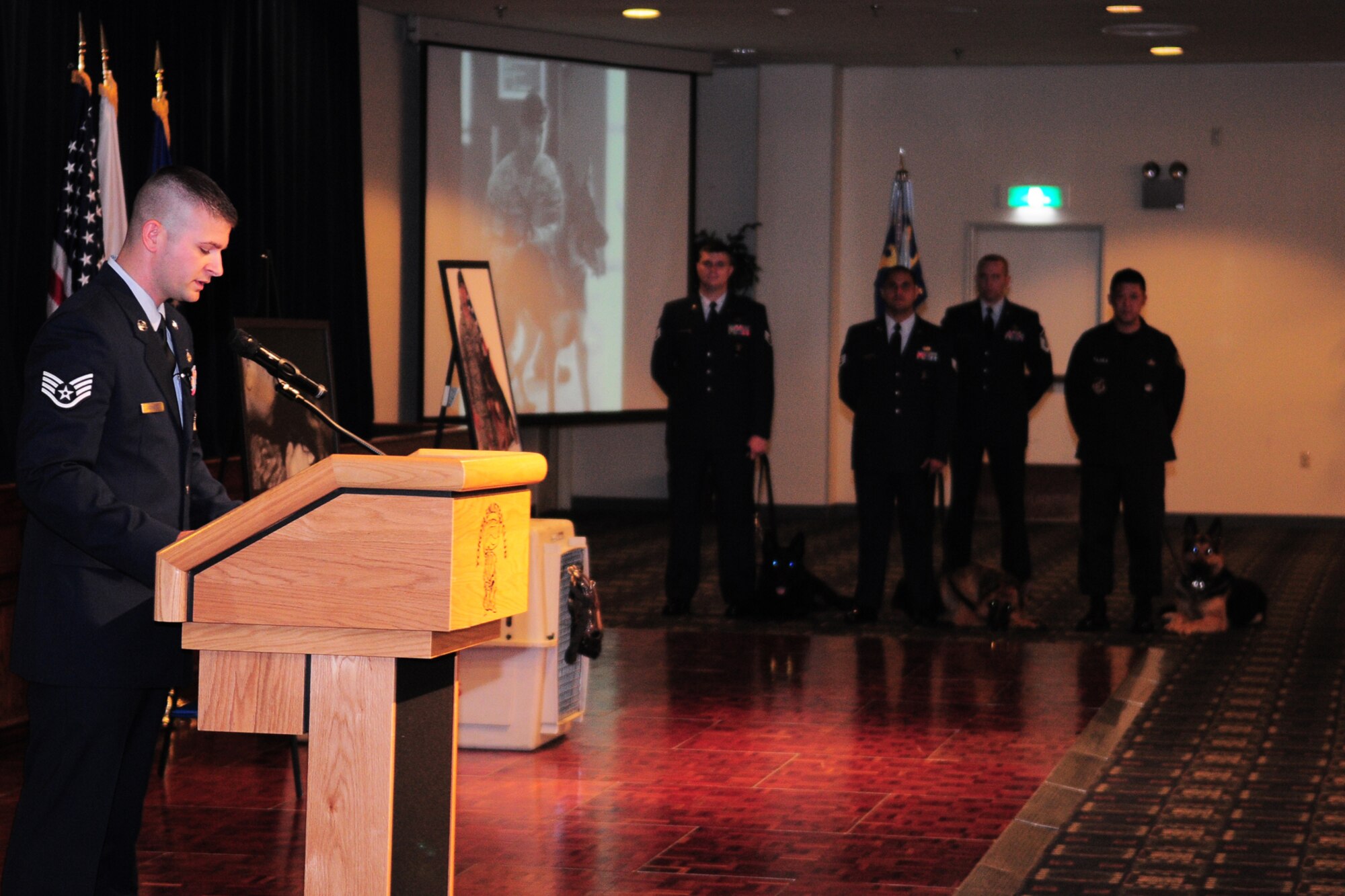 YOKOTA AIR BASE, Japan -- Staff Sgt. Sanford Gschwend, 374th Security Forces Squadron military working dog handler, reads the eulogy at a memorial service for MWD Pixi at the enlisted club here recently. Pixi, a 3-year-old German Shepherd, died Sept. 22. (U.S. Air Force photo/Airman 1st Class Michael Dillon)