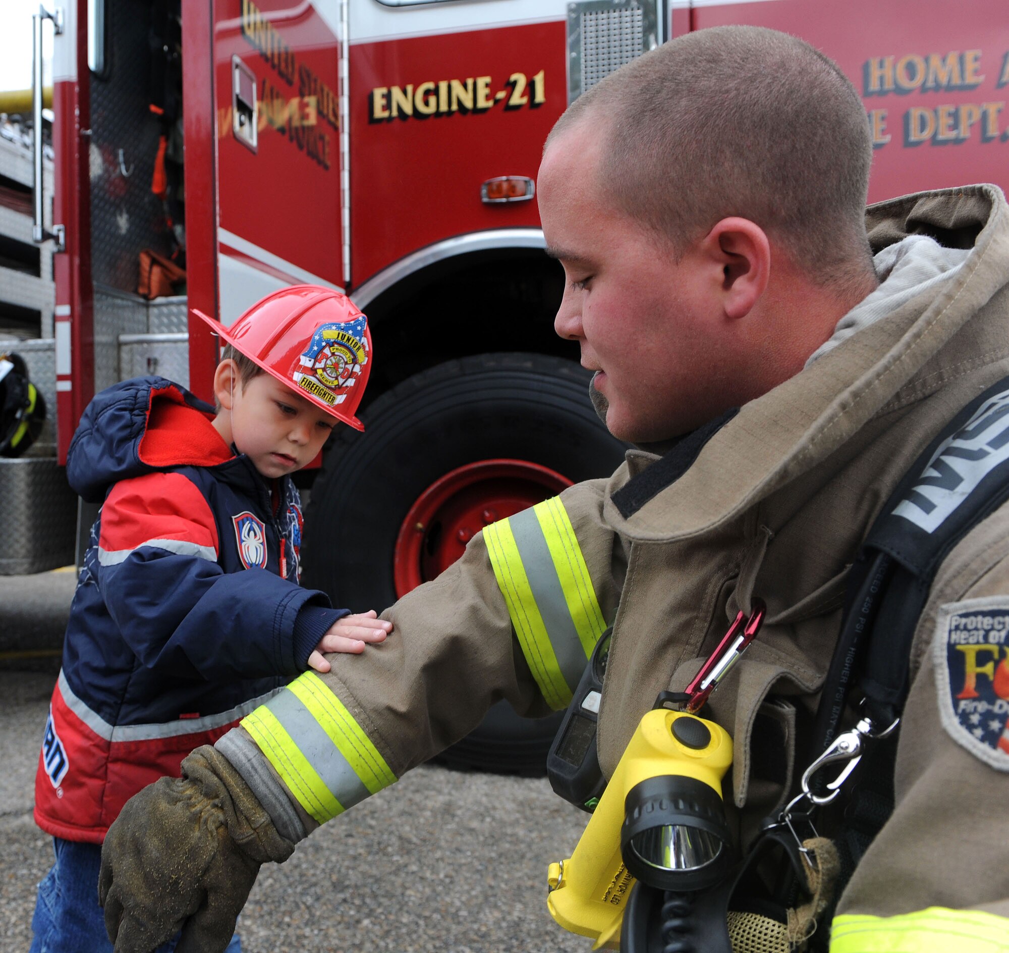 MOUNTAIN HOME AIR FORCE BASE, Idaho -- Airman Josh Hartman, 366th Civil Engineer Squadron base firefighter, shows Jozseph his uniform during Fire Prevention Week Oct. 5 at the Child Development Center. This is the 88th year fire departments have observed Fire Prevention Week, making it the longest running public health and safety observance on record. (U.S. Air Force photo by Airman 1st Class Debbie Lockhart)