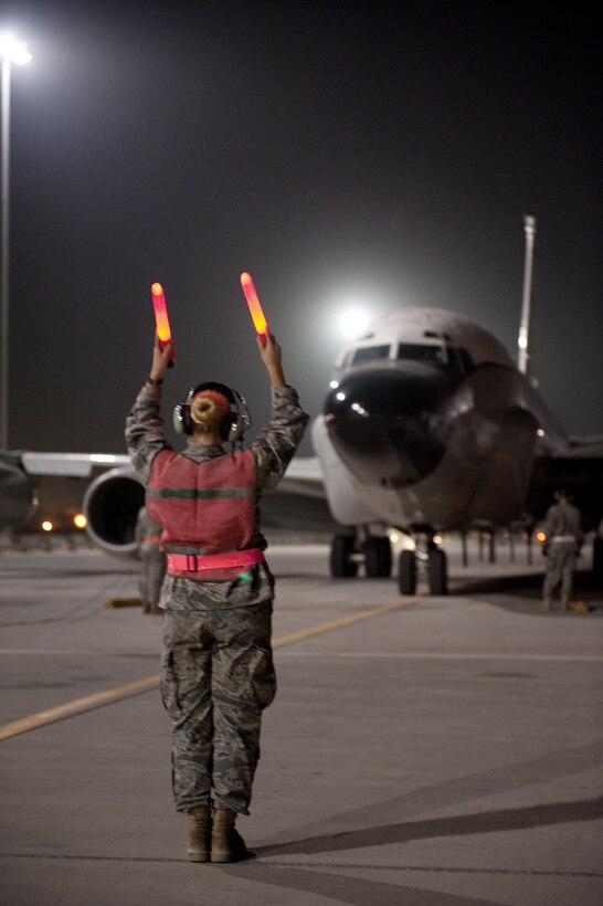 Senior Airman Jayme Warner guides a RC-135V/W Rivet Joint Oct. 7, 2009, at an air base in Southwest Asia. Airman Warner is a 55th Aircraft Maintenance Unit engine mechanic deployed from Offutt Air Force Base, Neb. (U.S. Air Force photo/Staff Sgt. Robert Barney)