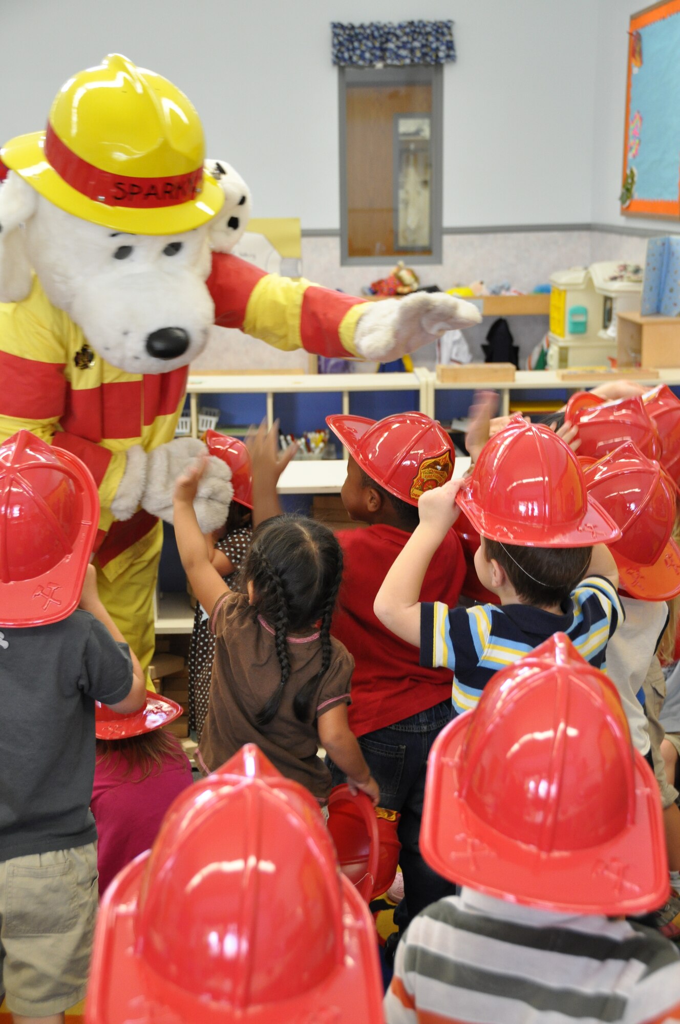 Sparky the fire dog, visits a group of children at the Child Development Center Oct. 8 to talk about National Fire Prevention Week.  National Fire Prevention Week 2009 is from Oct. 4 to Oct. 10, and this year’s theme focuses on burn awareness and keeping homes safe from the leading causes of home fires.  (U.S. Air Force photo/Airman 1st Class Veronica McMahon)