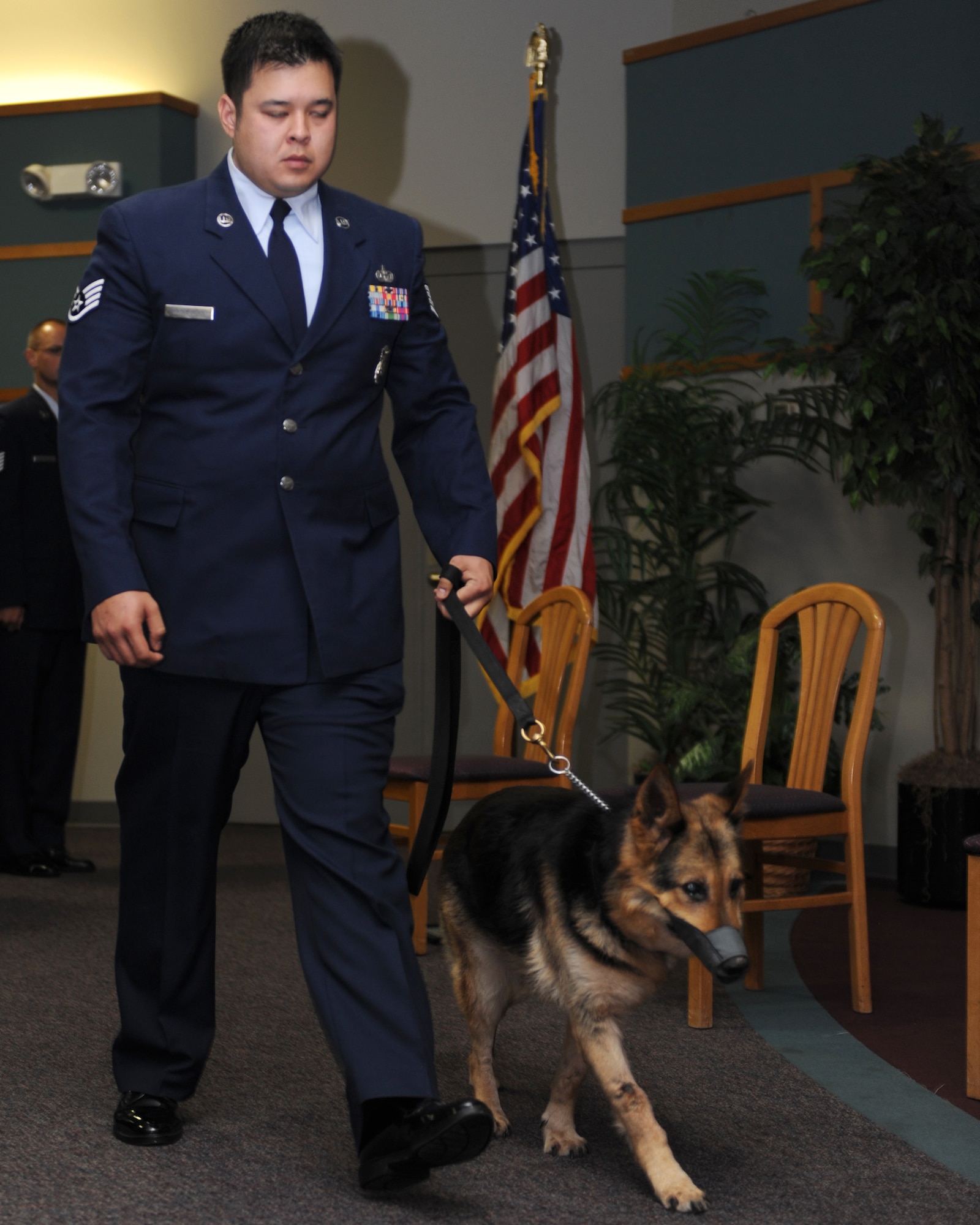 WHITEMAN AIR FORCE BASE, Mo. – Military Working Dog, Tina exits the room with her former trainer and now owner Staff Sgt. Bobby Haguewood, 509th Security Forces Squadron MWD handler, during her retirement ceremony from active duty, Oct 8. MWDs Charlie, Joost, Rico, and Tina retired from active duty service Oct. 8 after more than 35  combined years of service to their country. (U.S. Air Force Photo/ Senior Airman Cory Todd)