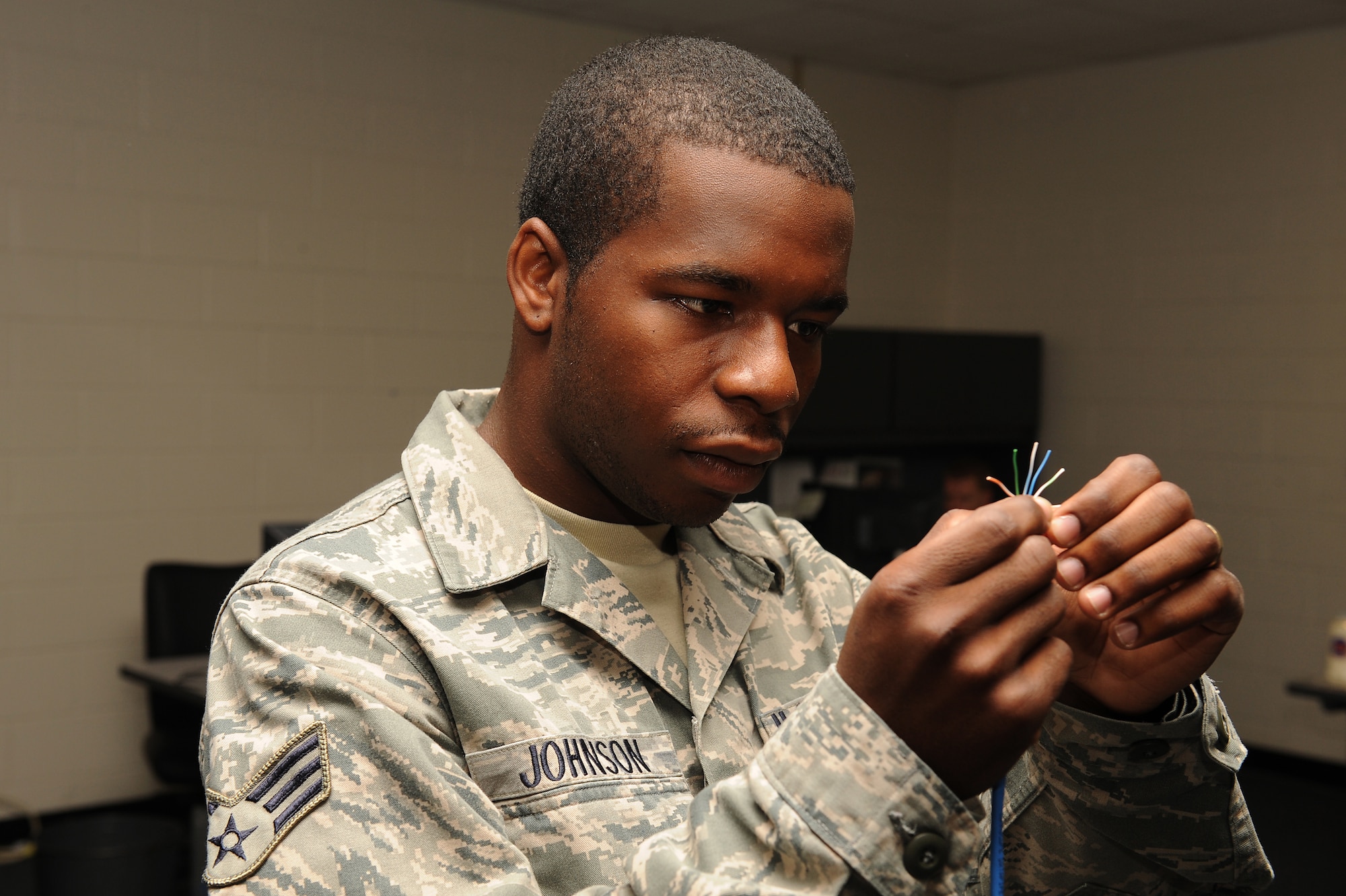 Senior Airman Nathaniel Johnson III, 4th Communications Squadron client support administrator, places local area network cable wires in the proper order to allow computers to connect to the base network on Seymour Johnson Air Force Base, N.C., Oct. 1, 2009. Airman Johnson travels to every office on base solving printer, digital sender, computer, Microsoft program and LAN cable problems.  (U.S. Air Force photo/Airman 1st Class Whitney Lambert)