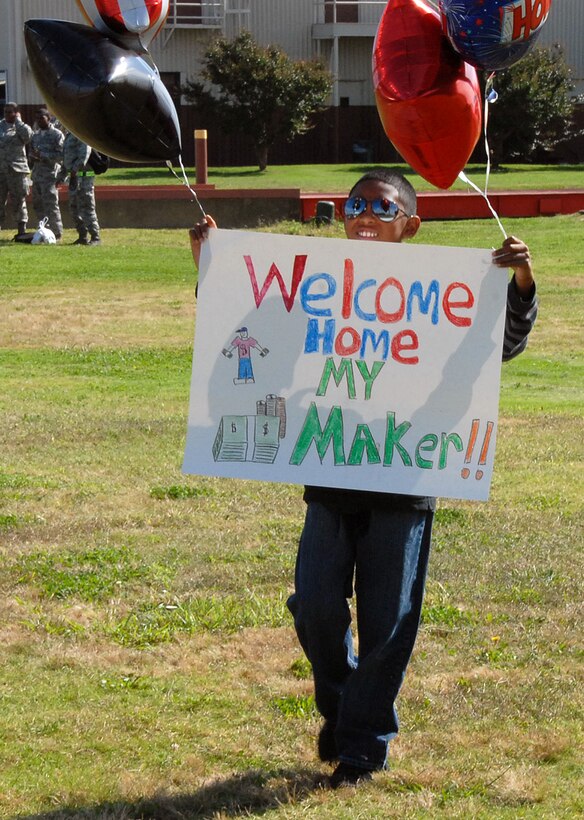 LANGLEY AIR FORCE BASE, Va. – Cameron Dionisio, son of Tech. Sergeant Donnie C. Dionisio, 1st Fighter Wing, displays a custom poster for his father’s arrival here Oct.1.  More than 150 Airmen returned from a 120-day deployment to Kadena Air Base, Japan. The goal of the deployment was to support the Pacific Theater Security Package and ensure stability in the region. (U.S. Air Force Photo/Master Sgt. Carlos J. Claudio)