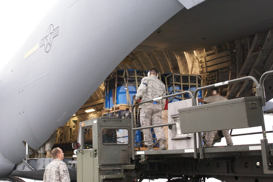 ELMENDORF AIR FORCE BASE, Alaska – Members of Elmendorf's 732nd Air Mobility Squadron load cargo on board a McChord C-17 Globemaster III Oct. 7. More than 58,000 pounds of cargo - seven pallets of fuel for expeditionary hospital emergency generators and three pallets of medical supplies, ultimately destined for Indonesia - were loaded aboard the aircraft. (U.S. Air Force photo/Staff Sgt. Eric Burks)