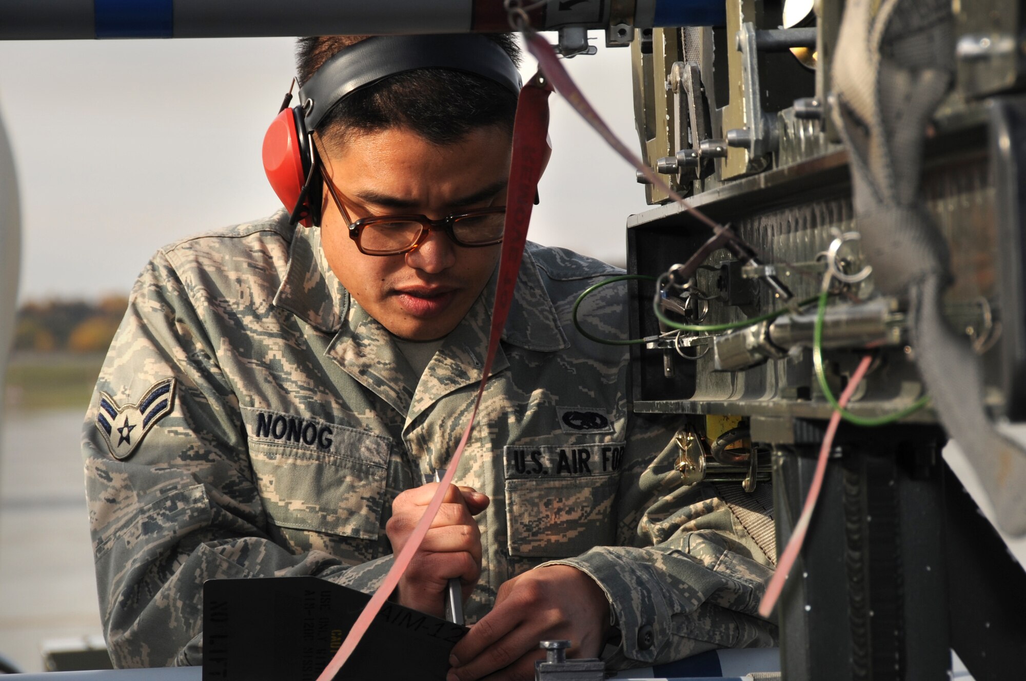 ELMENDORF AIR FORCE BASE, Alaska -- Airman 1st Class John Nonog installs a wing on an air intercept missile Oct. 2.Three load teams from the 3rd Wings Aircraft Maintenance Units participated in a load crew competition on the flight line. Nonog is an Aircraft Armament specialist with the 90th Aircraft Maintenance Unit. (U.S. Air Force Photo/ Senior Airman Cynthia Spalding)