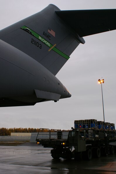 A 60K-Tunner approaches a McChord C-17 Globemaster III with cargo for a humanitarian mission Oct. 7 at Elmendorf Air Force Base, Alaska. More than 58,000 pounds of cargo - seven pallets of fuel for expeditionary hospital emergency generators and three pallets of medical supplies, ultimately destined for Indonesia - were loaded aboard the aircraft. (U.S. Air Force photo/Staff Sgt. Eric Burks)