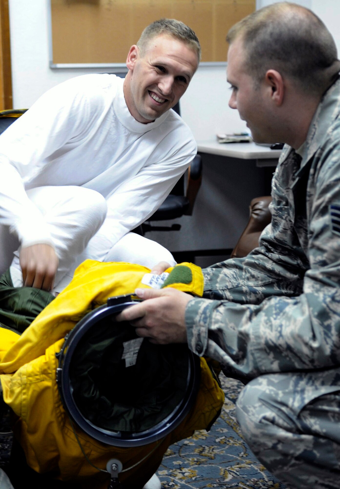 Staff Sgt. Mark Reith helps Capt. Peter J. Gryn don his specialized suit before a flight Oct. 4, 2009. The sortie was Captain Gryn's first combat mission. Both Airmen are deployed from Beale Air Force Base, Calif. (U.S. Air Force photo/Staff Sgt. J.G. Buzanowski)