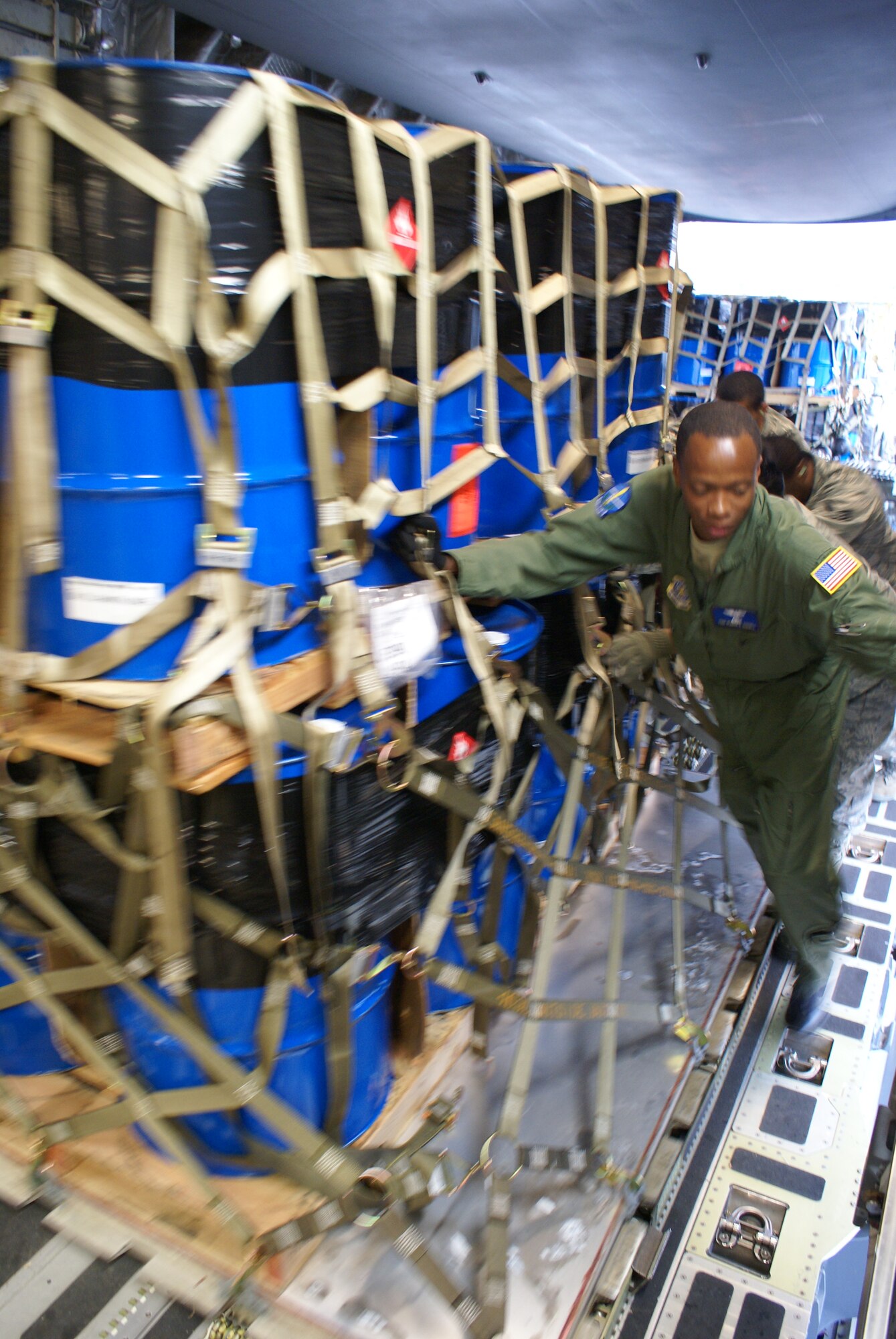 Tech. Sgt. Derrick Russell, 7th Airlift Squadron, loads cargo on board a McChord C-17 Globemaster III Oct. 7 at Elmendorf Air Force Base, Alaska. More than 58,000 pounds of cargo - seven pallets of fuel for expeditionary hospital emergency generators and three pallets of medical supplies, ultimately destined for Indonesia - were loaded aboard the aircraft. (U.S. Air Force photo/Staff Sgt. Eric Burks)