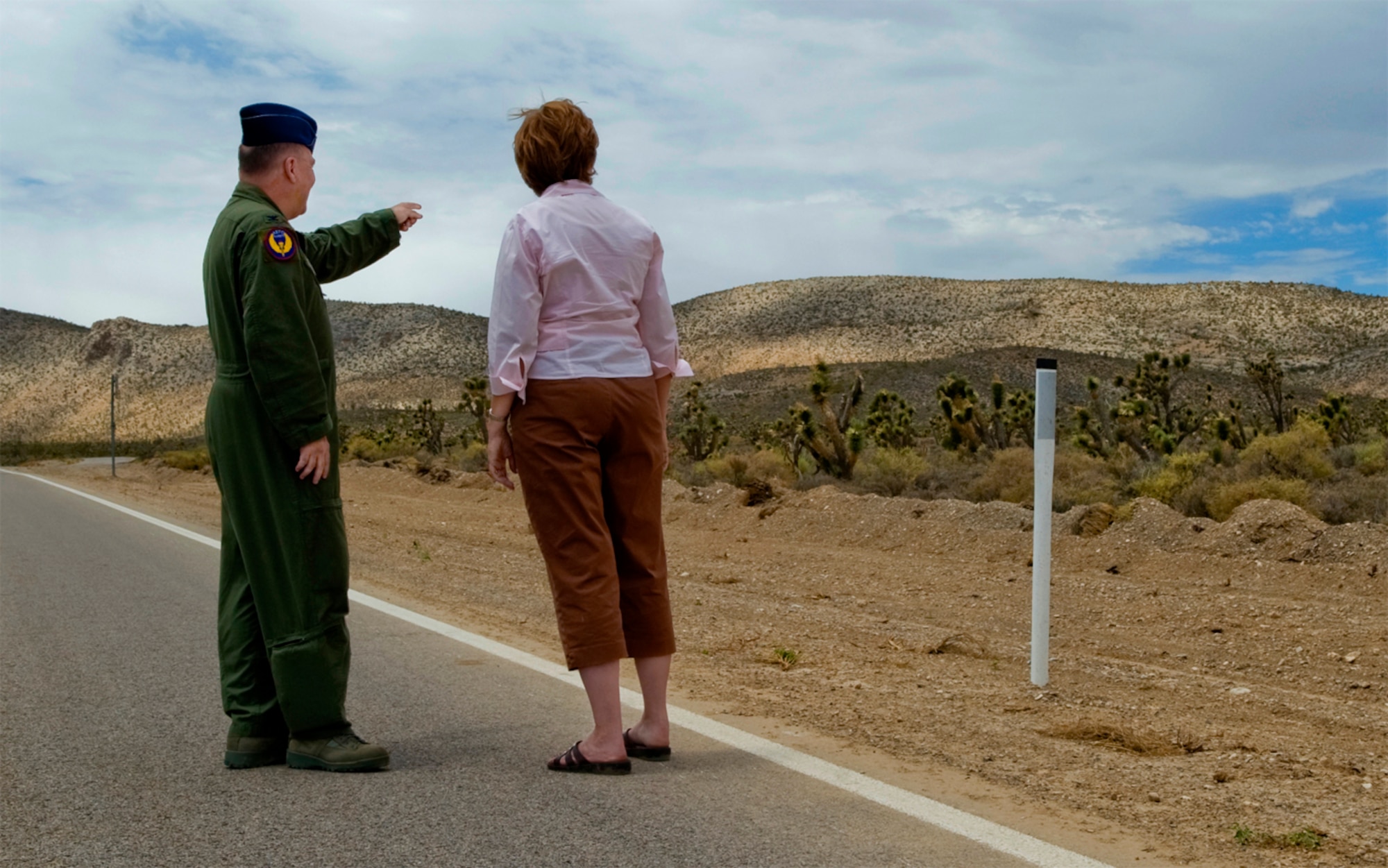 DISASTER IN THE DESERT - Pointing in the direction the rescue helicopter landed, Col. John W. Blumentritt and Elaine Hardy reminisce at the site of the bus crash that nearly cost Hardy her right leg. Inset, Hardy's eyes well up as she recounts the emotional details of the mishap. (U.S. Air Force photo by / Staff Sgt. Bennie J. Davis III)