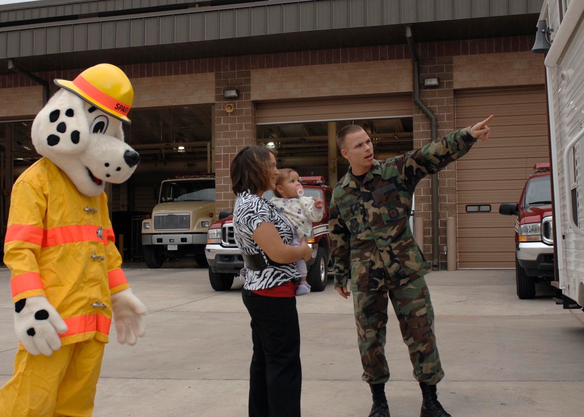 CANNON AIR FORCE BASE, N.M.-- Airman 1st Class Randall Forsythe, 27th Special Operaitons Civil Engineer Squadron, and Sparky the fire dog show Shanannah and Alivianna Forsythe around the fire department during an open house during Fire Prevention Week Oct. 7. The fire muster has changed dates and will now be held on  Oct. 16 at Doc Stewart Park.  (U.S. Air Force photo by Airman 1st Class James Bell)