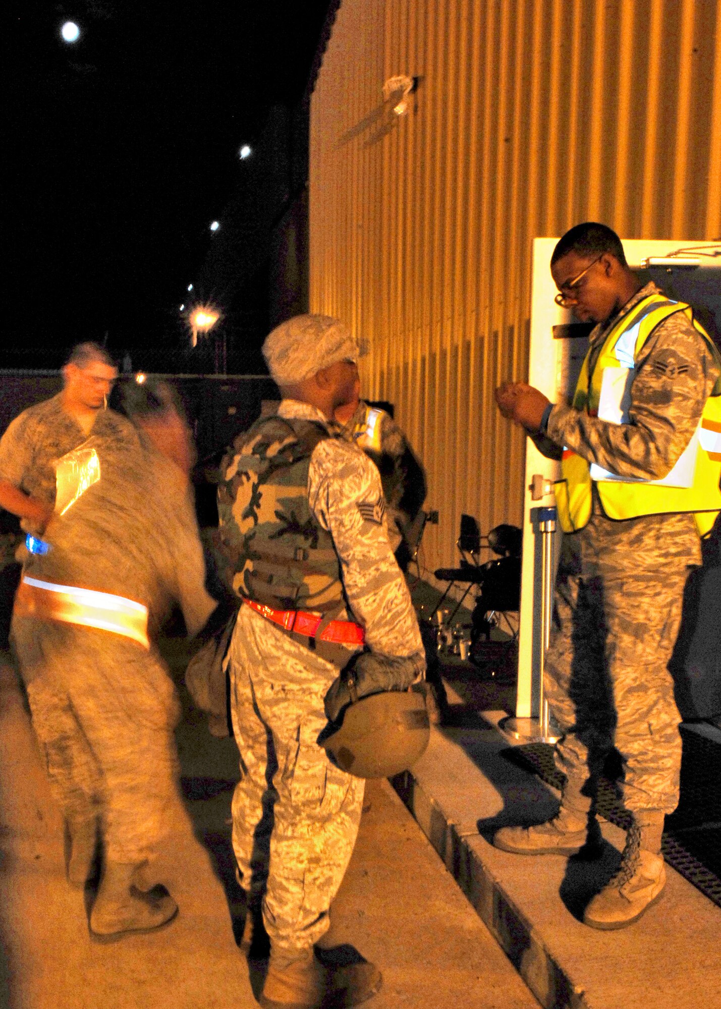HOLLOMAN AIR FORCE BASE, N.M. -- Airman 1st Class Muhammed Ahmed, 49th Force Support Squadron, checks Staff Sgt. Roland Vinge's, 49th Material Maintenance Support Squadron, military identification card before giving him access to enter the Personnel Deployment Facility during Exercise Cornet Gold Rush at Basic Expeditionary Airfield Resources Base here, Oct. 6. Airman Ahmed is a customer support apprentice participating in an exercise scenario consisting of processing Airmen for deployment.  (U.S. Air Force photo by Staff Sgt. Anthony Nelson Jr)
