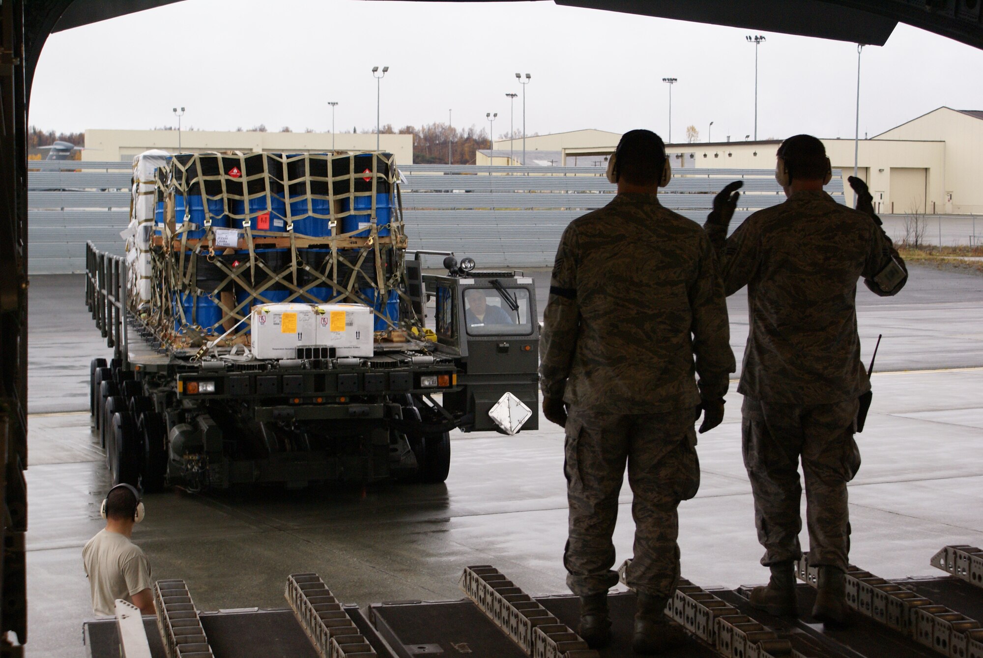 Elmendorf Air Force Base, Alaska, 732nd Air Mobility Squadron Airmen marshal in a 60K-Tunner with cargo for a McChord C-17 Globemaster III on a humanitarian airlift mission Oct. 7. More than 58,000 pounds of cargo - seven pallets of fuel and three pallets of medical supplies, ultimately destined for Indonesia - were loaded aboard the aircraft. (U.S. Air Force photo/Staff Sgt. Eric Burks)
