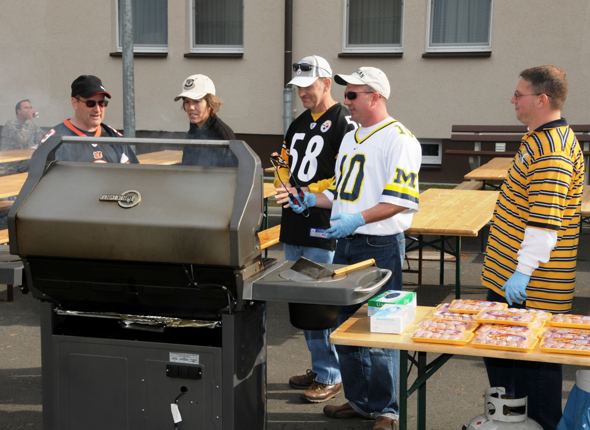 LANDSTUHL ARMY MEDICAL CENTER, Germany -- (Left to right) 17th Air Force members Lt. Col. Ron Taylor, Mrs. Ann Callan, Vice Commander Brig. Gen. Michael Callan, Senior Master Sgt. Jim Downey, and Master Sgt. Michael McNeil prepare burgers and bratwurst for the USO Wounded Warrior Cookout here Oct. 3. Members of 17th AF, also known as Air Forces Africa, joined forces with the USO to put on the event, which also featured live music, to show appreciation to the many wounded U.S. and coalition troops receiving care at LRMC after being MEDEVACed  from Afghanistan and Iraq. (USAF photo by Master Sgt. Jim Fisher) 