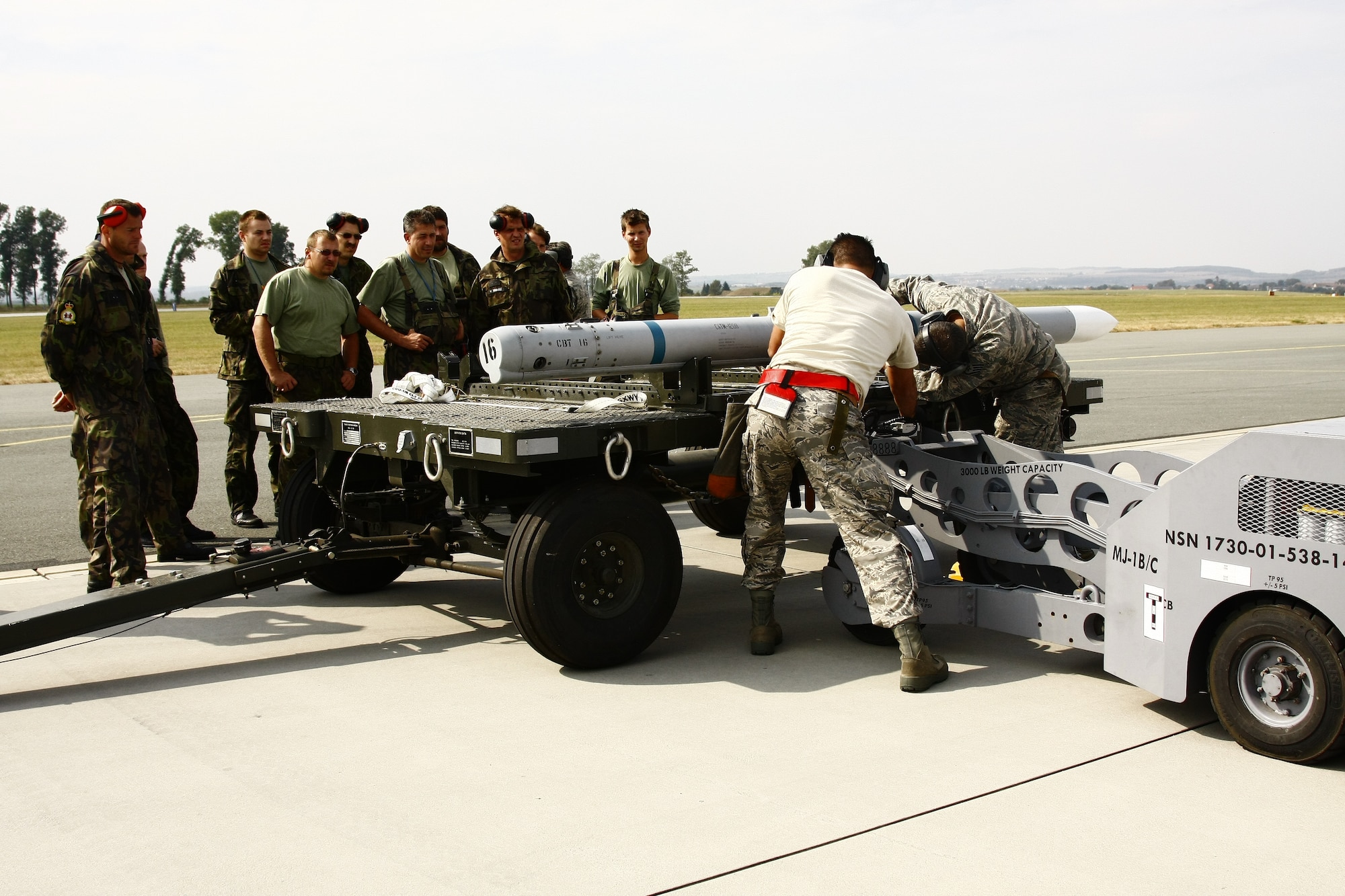 Czech aircraft maintainers look on as American weapons loaders prep a missile for installation at Caslav Air Base.  Members of the Texas Air National Guard’s 149th Fighter Wing were in the Czech Republic conducting mutual training as part of the National Guard’s state partnership program.  (U.S. Air Force photo by Capt Randy Saldivar)