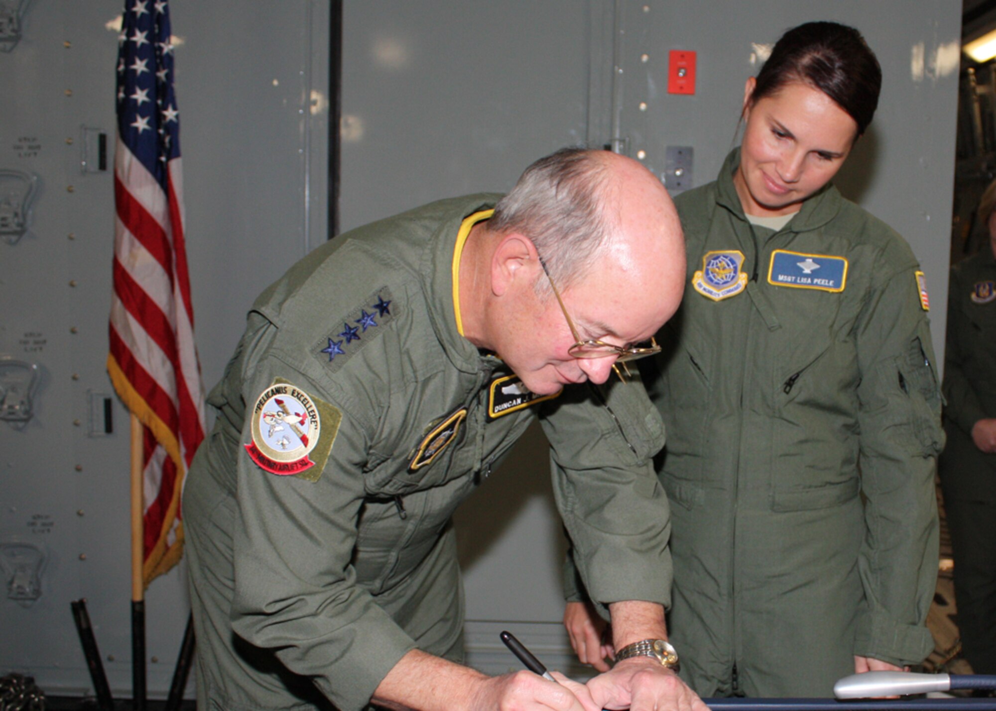 Gen. Duncan McNabb, U.S. Transportation Command commander, signs Master Sgt.
Lisa Peele's reenlistment papers after officiating her reenlistment on Sgt.
Peele's first-ever C-17 flight.  Sergeant Peele will attend the First
Sergeant Academy beginning Oct. 25 and is designated to become the first
sergeant for Charleston's 14th Airlift Squadron after graduation.  Sergeant
Peele's new assignment comes little more than two years after an accident
claimed her husband's life and severely injured her.  Her husband had
recently attended first sergeant training, as she was preparing to submit
her formal application for the First Sergeant Academy when the accident
occurred.
