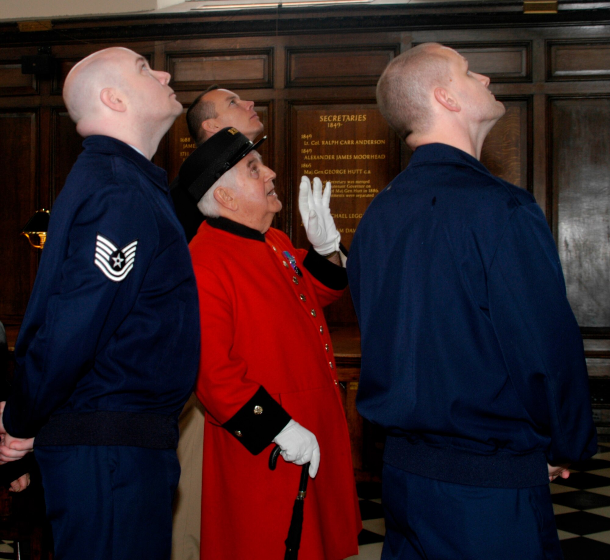 Mr. Tom Mullauny, tells the group (L-R US Navy Lt. Shawn Phillips, Mr. Tom Mullauny, US Air Force Tech. Sgt. Jonathan Sellers and US Air Force Tech. Sgt. Jeffrey Utter) the history of a painting in the dining room. (Photo by Melony Angelilli)