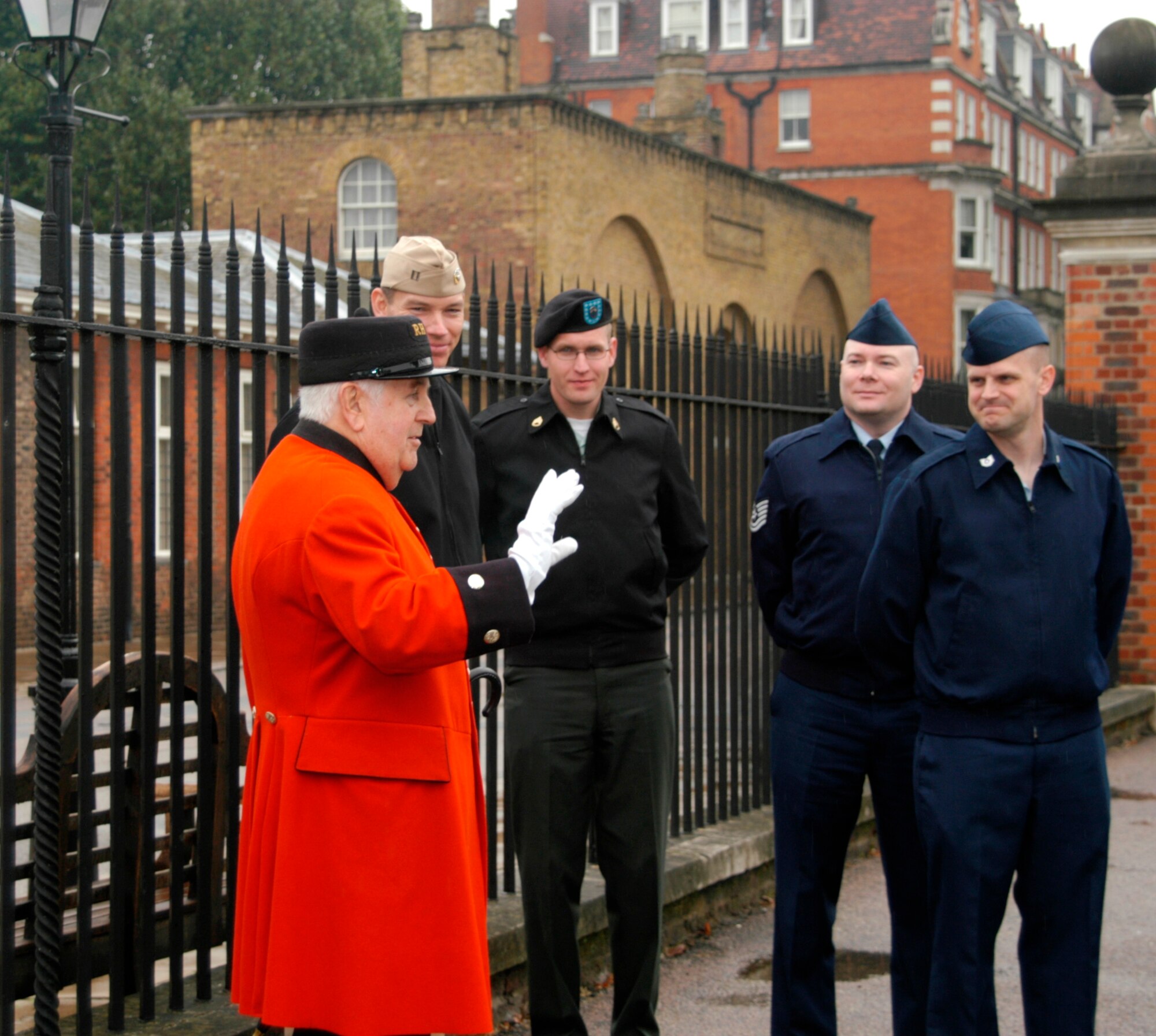 Royal Hospital Chelsea Pensioner and Tour Guide, Mr. Tom Mullauny, welcomes the group to his home (L-R Mr. Tom Mullauny, US Navy Lt. Shawn Phillips, US Army Staff Sgt. Joshua Miller, US Air Force Tech. Sgt. Jonathan Sellers and US Air Force Tech. Sgt. Jeffrey Utter).  (Photo by Melony Angelilli)